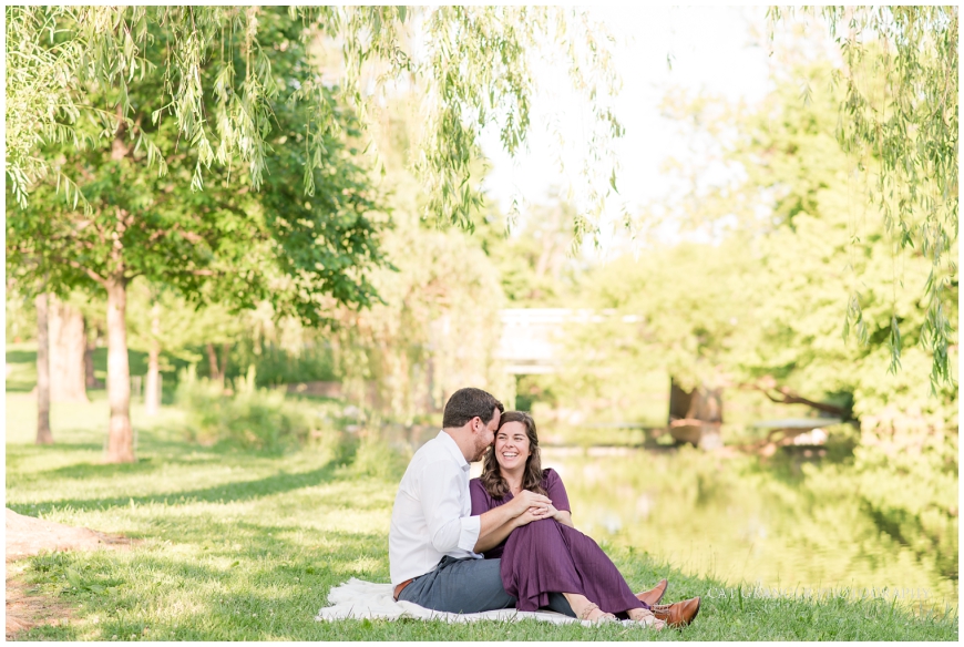 couple sitting by the water with willow trees