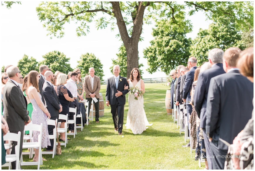  wedding ceremony at oak tree bluebird manor bride walking down