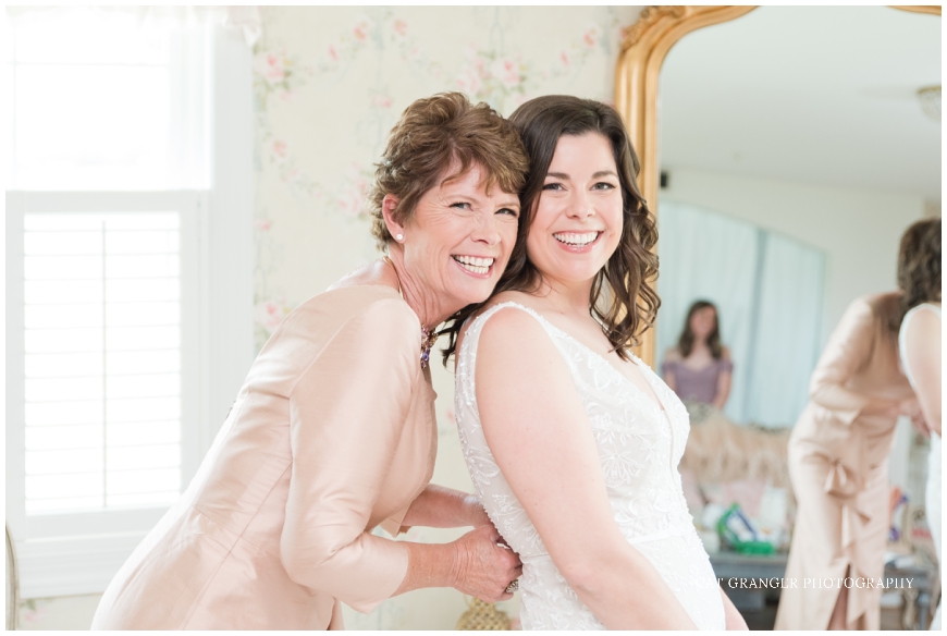 bride with mom buttoning dress