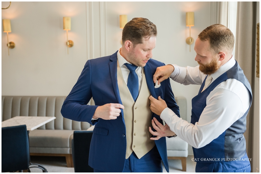 groom getting ready indoors blue suit champagne vest