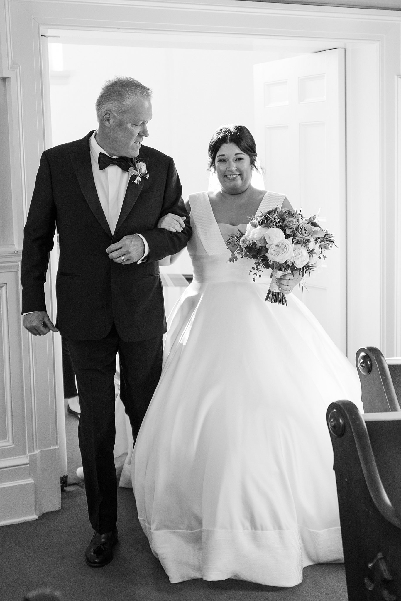A father walks his daughter down the aisle at her ceremony
