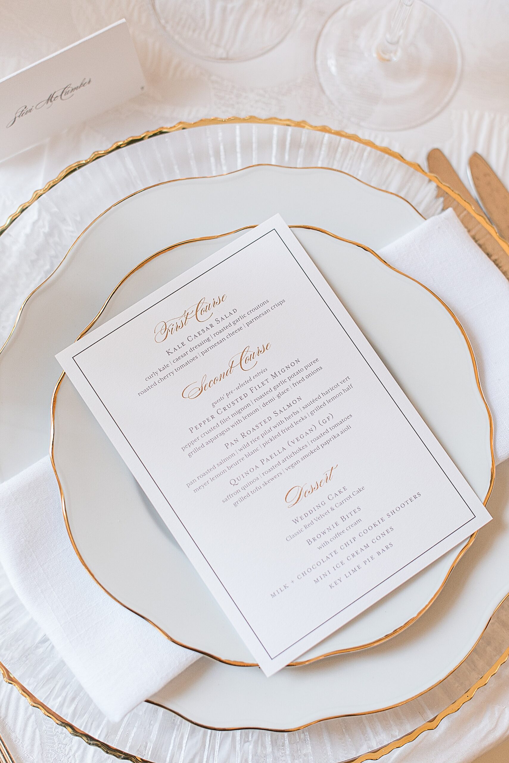 Details of a wedding reception menu on a plate with gold linings at one of the Baltimore Mansion Wedding Venues