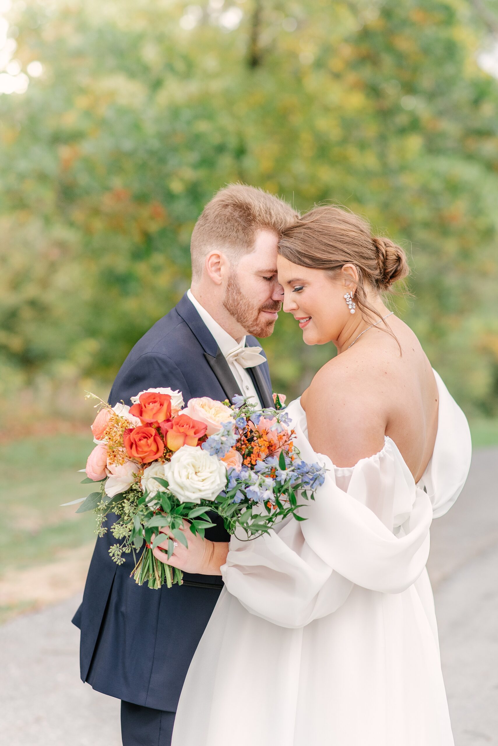 Newlyweds snuggle while standing in a garden at one of the Baltimore Mansion Wedding Venues