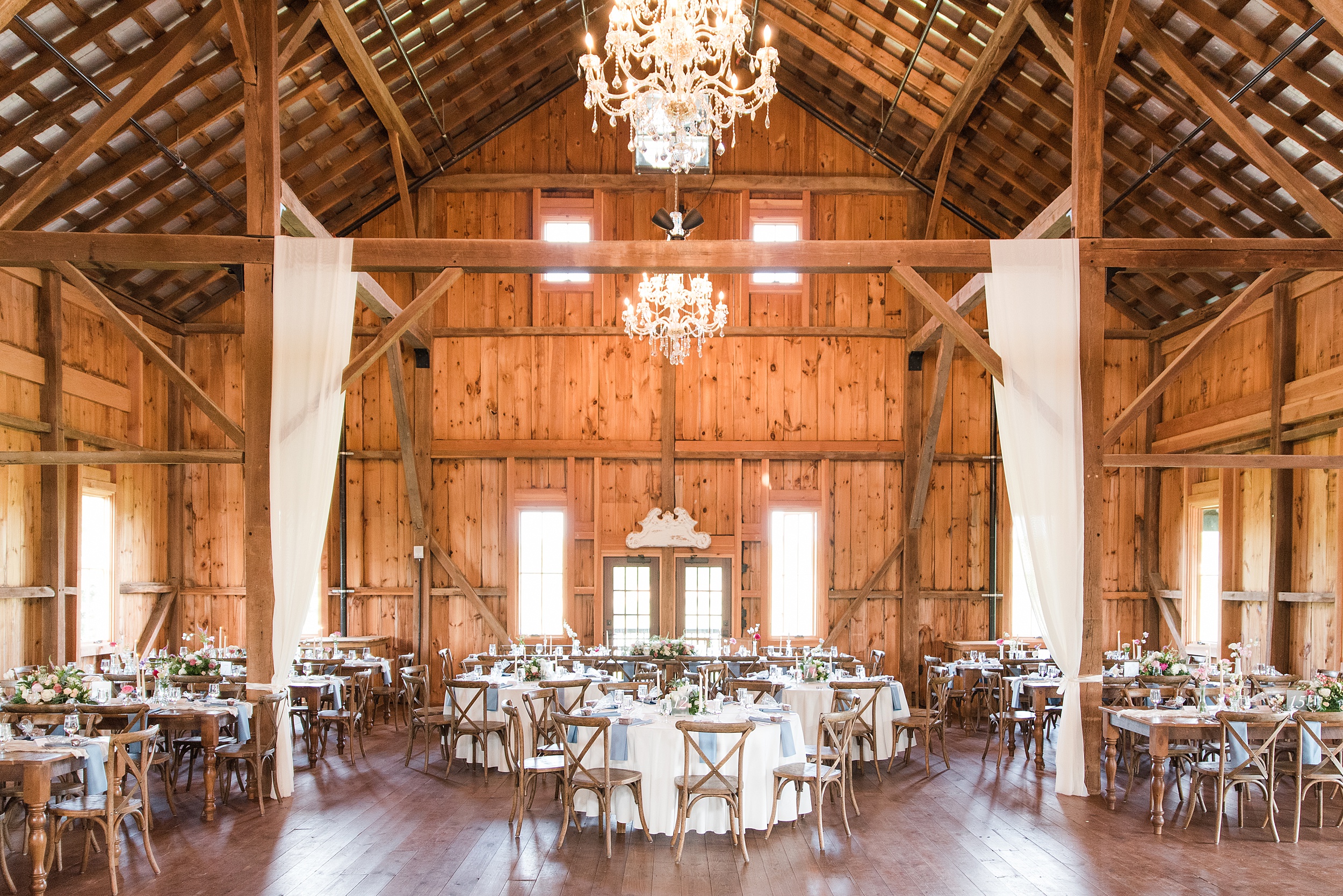 A view of a wedding reception set up in the barn of the Bluebird Manor wedding venue