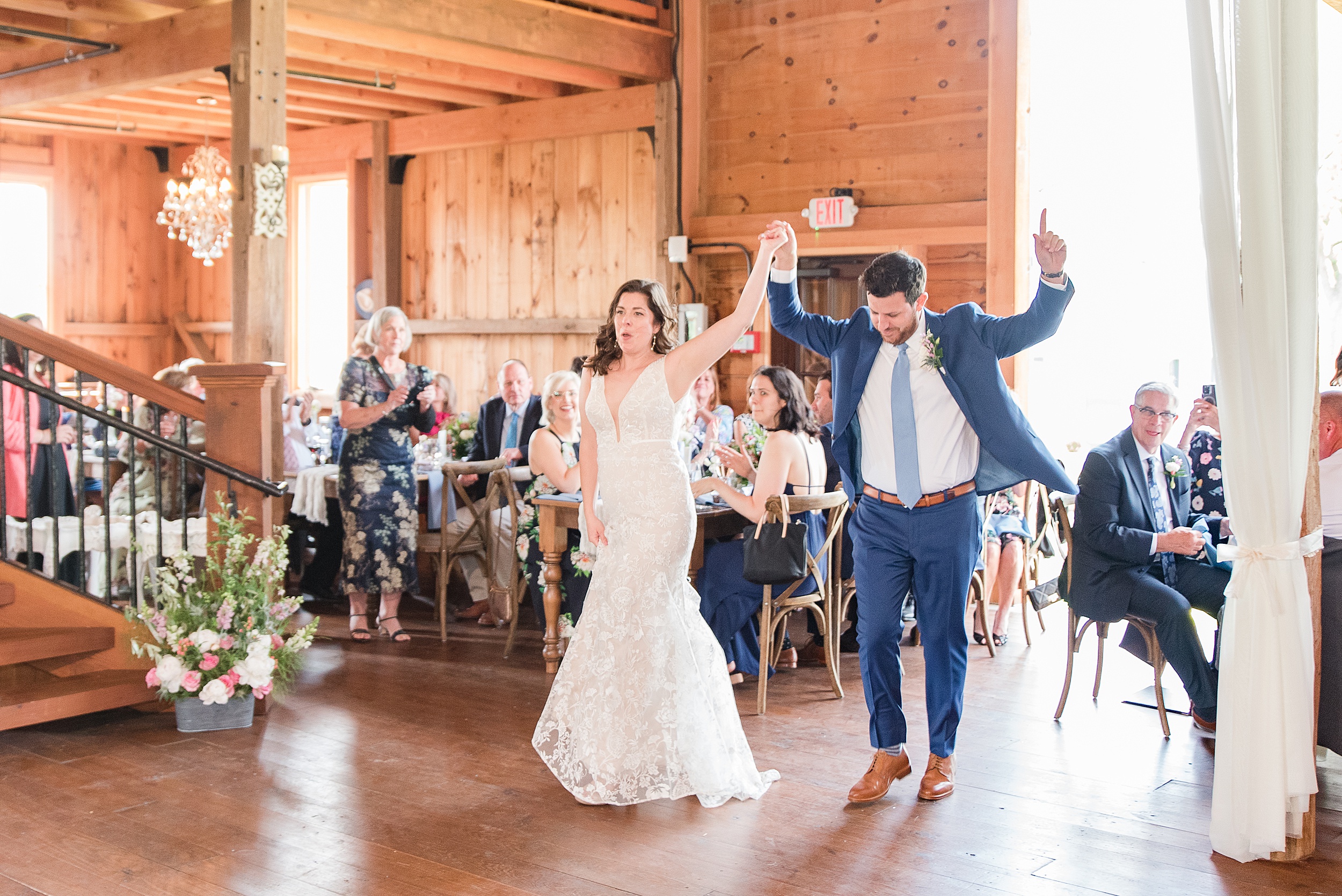 Newlyweds enter their Bluebird Manor wedding reception dancing with hands up