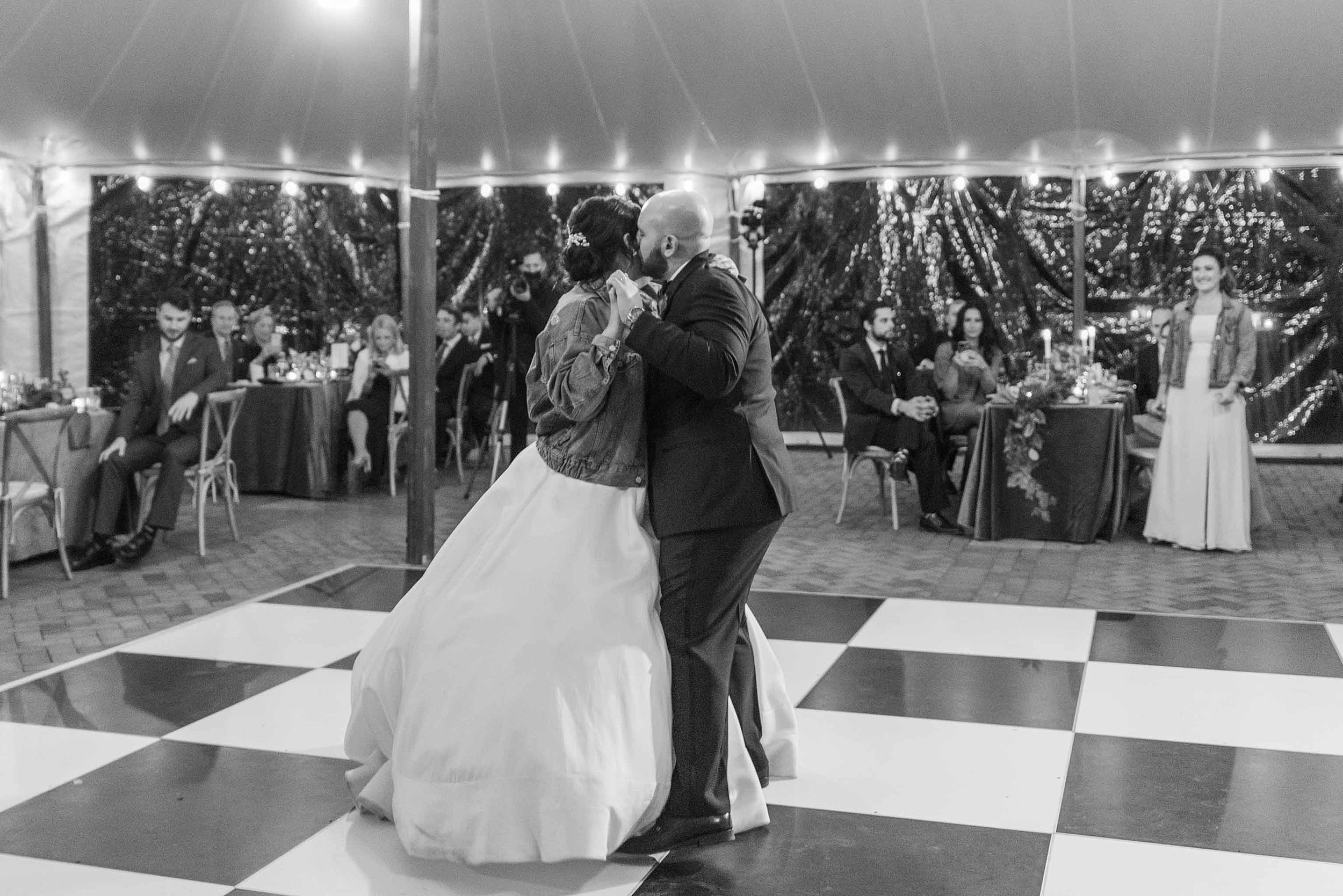 Newlyweds dance on a checker dance floor in a tent at their Brittland Estates Wedding