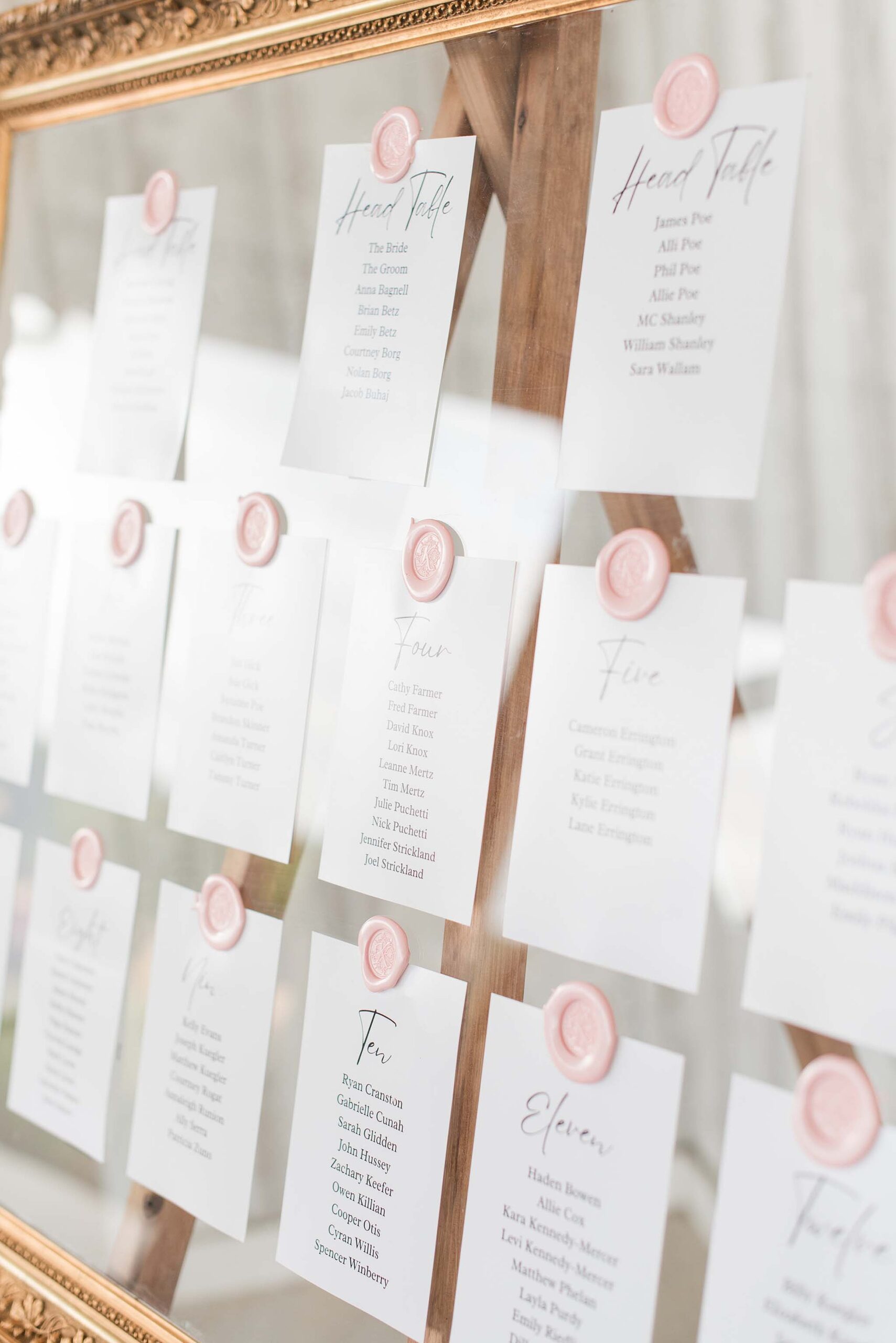 Details of a wedding table assignment board on a mirror