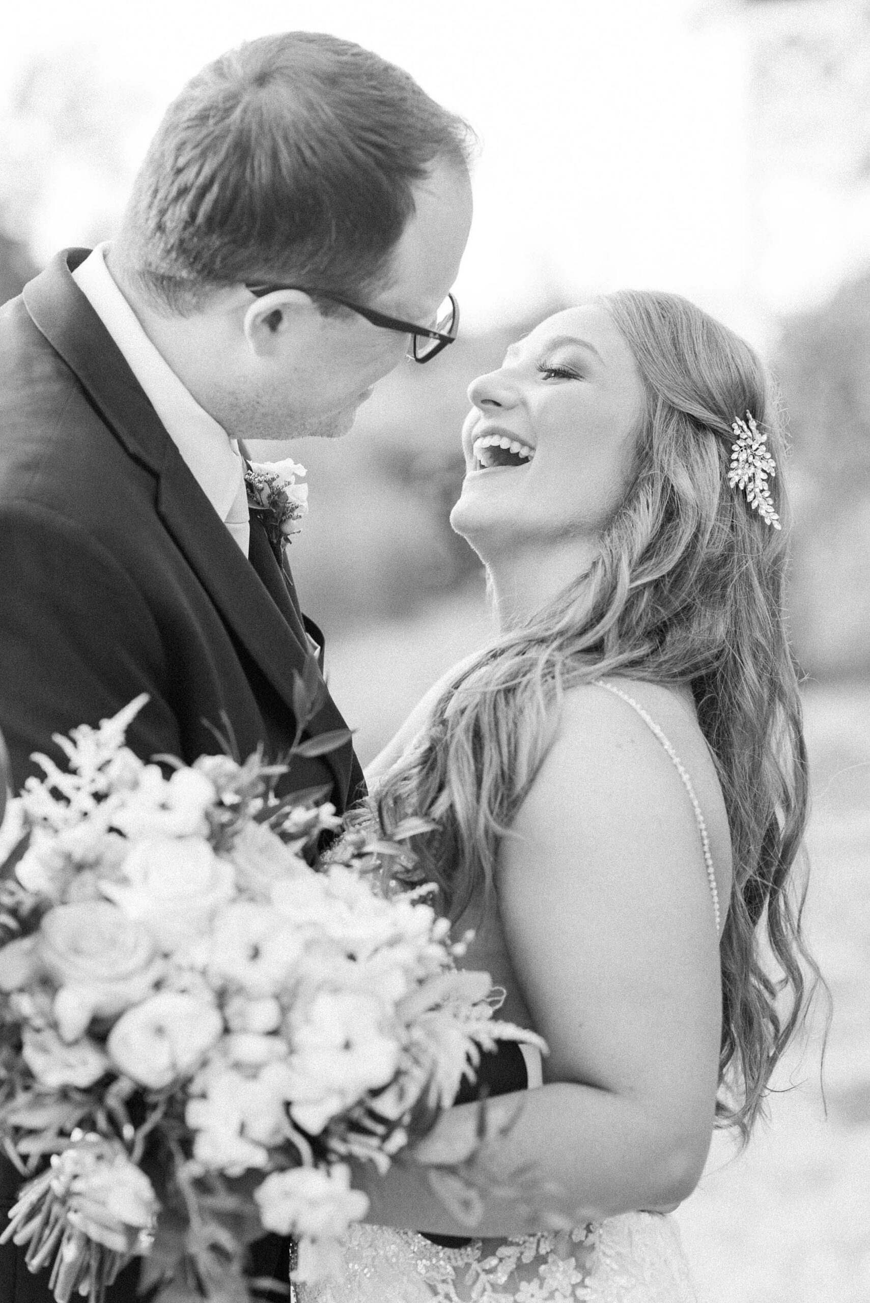 Newlyweds share a laugh while hugging outside at sunset