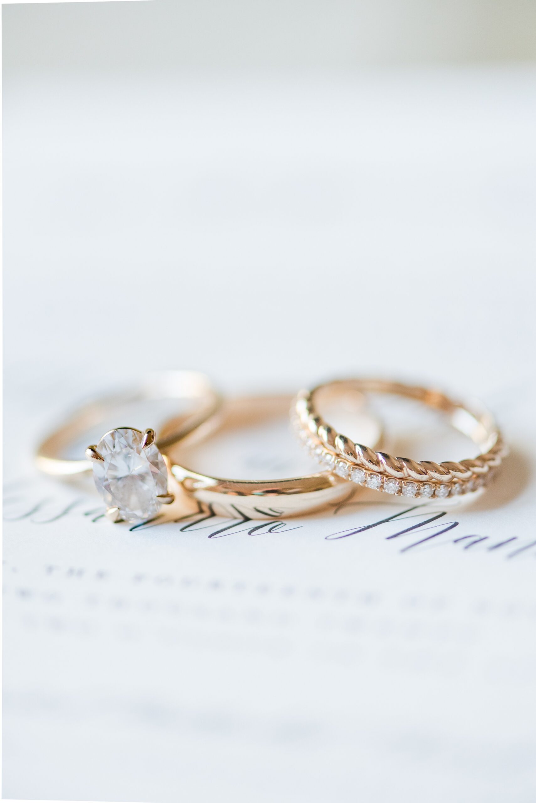 Details of wedding bands and ring sitting on an invitation