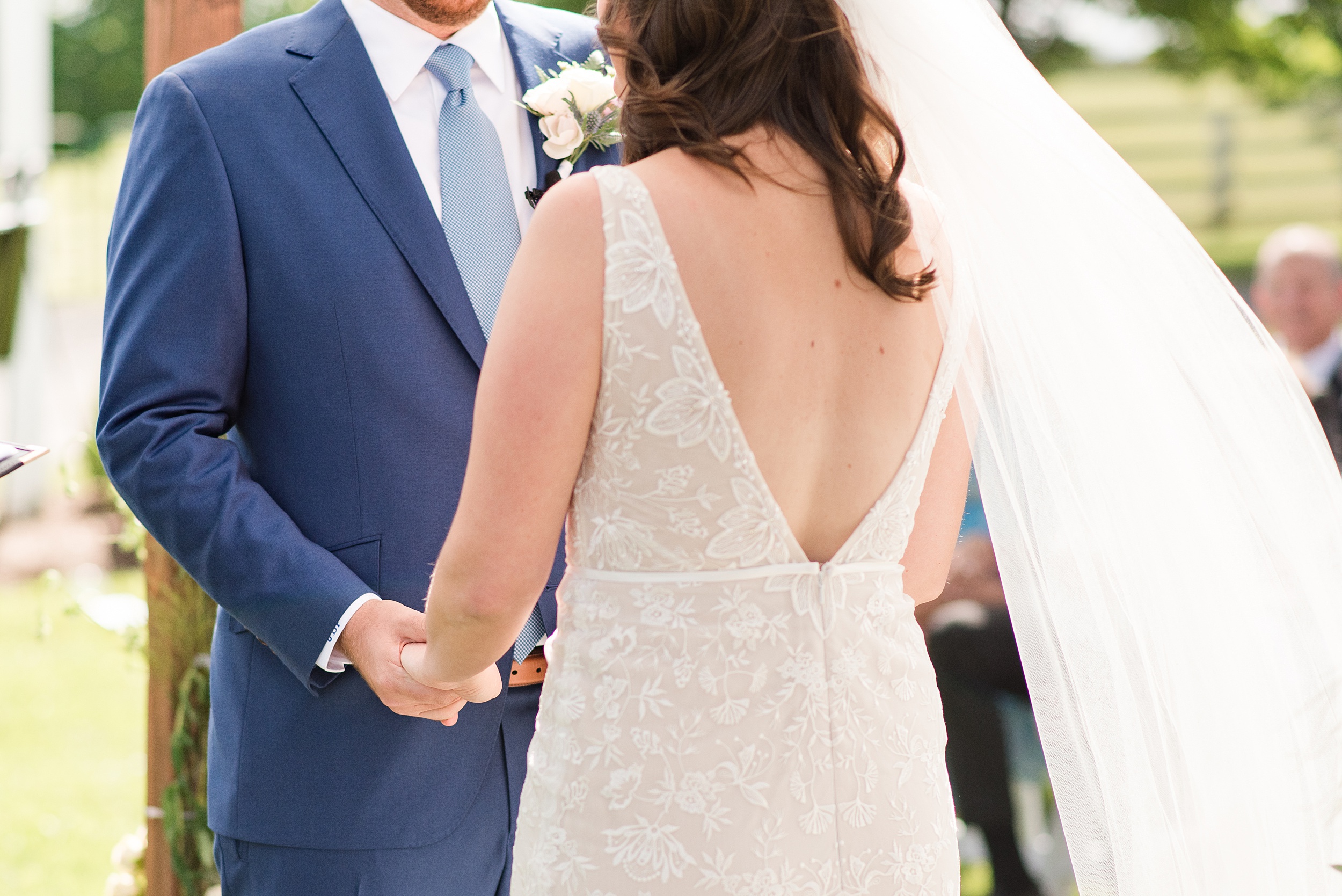 Newlyweds hold hands during their outdoor ceremony at their Historic Oakland Wedding