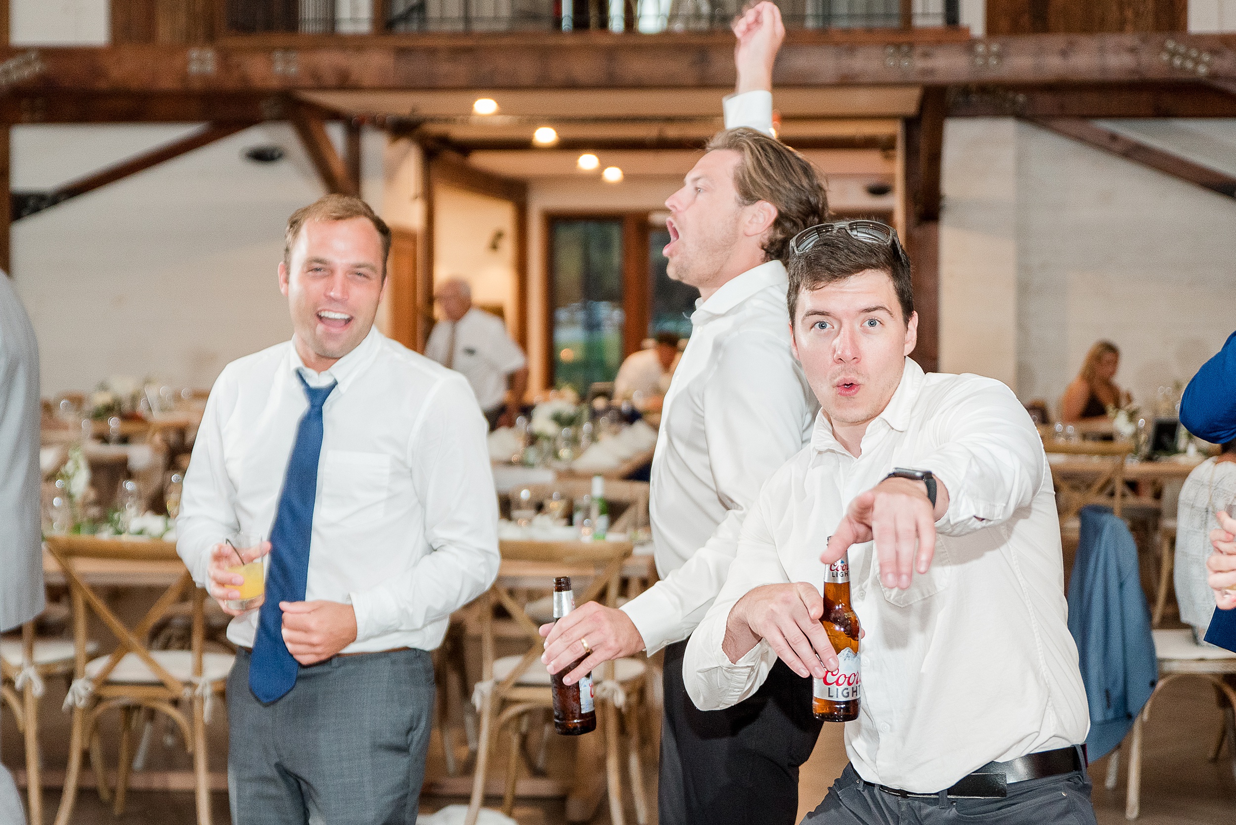 A group of groomsmen dance wildly during a wedding reception