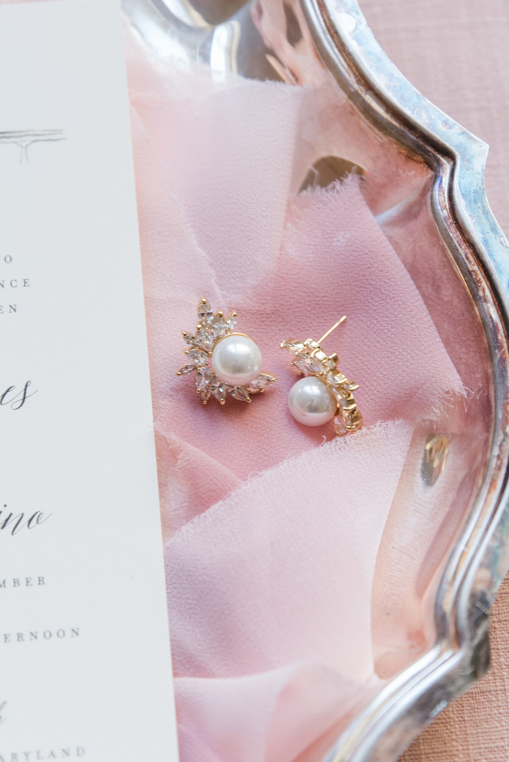 Details of pearl earrings sitting in a silver platter