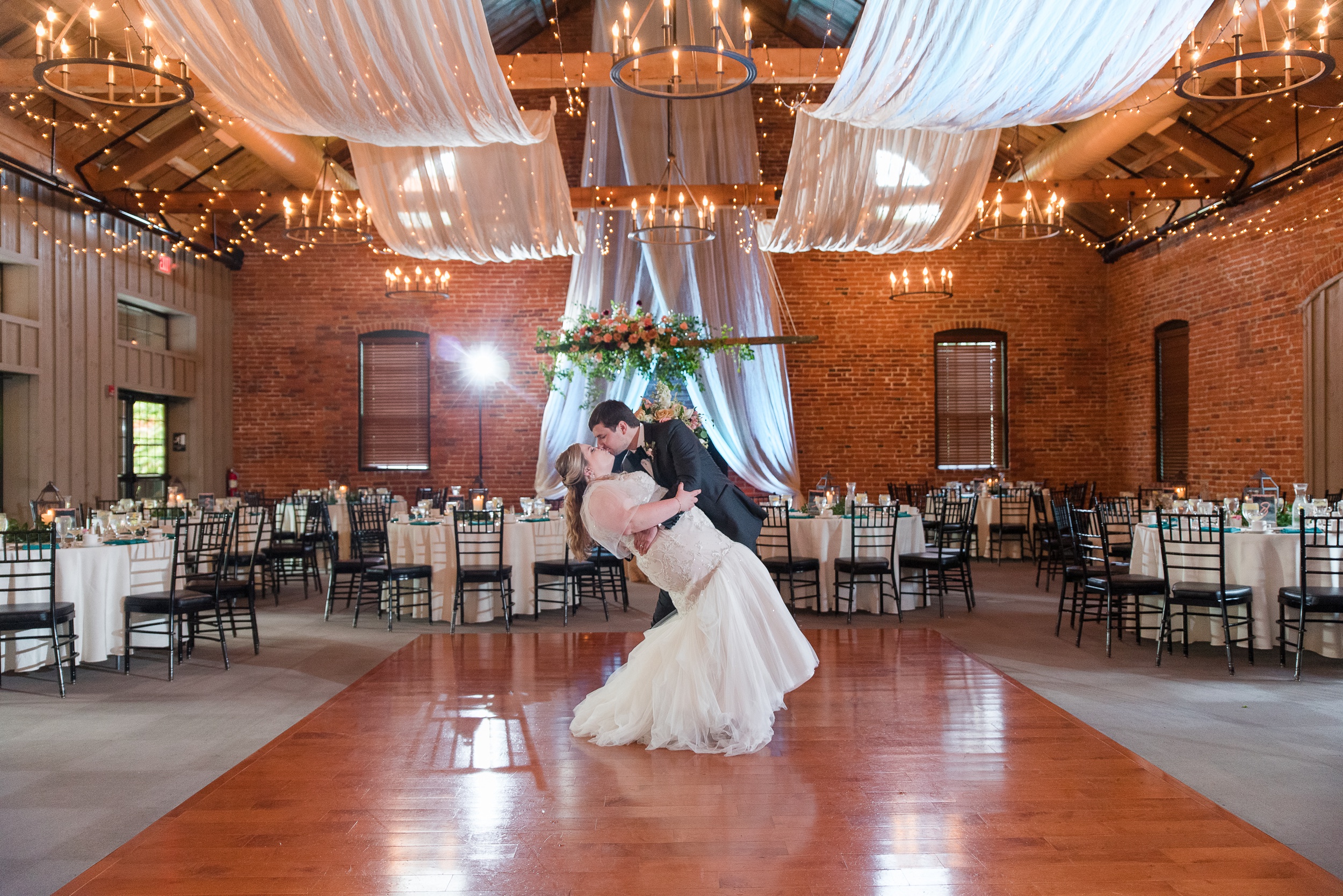 A groom dips his bride in the middle of the empty dance floor at their Cork Factory Hotel Wedding reception venue