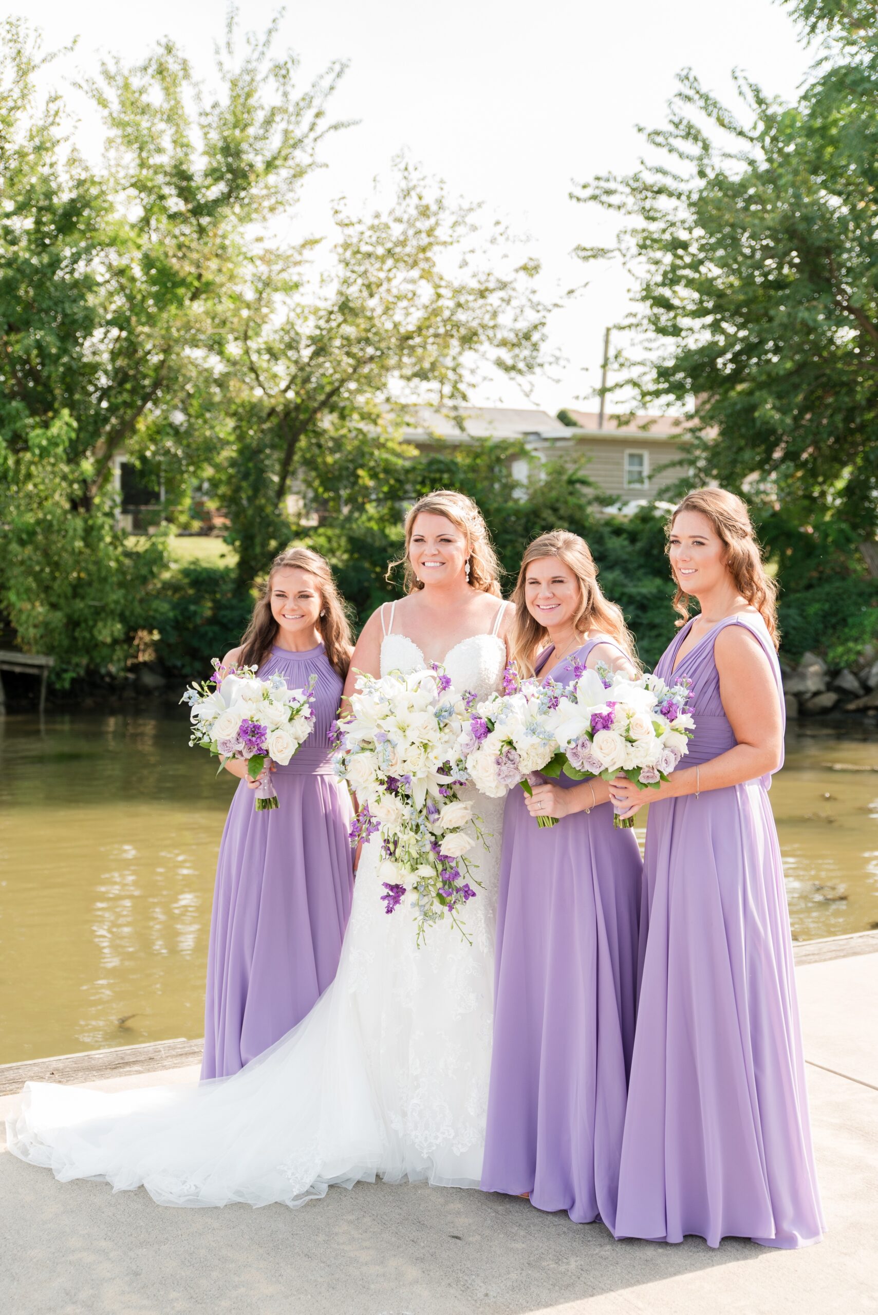 A bride holds her bouquet with her bridesmaids in matching dresses