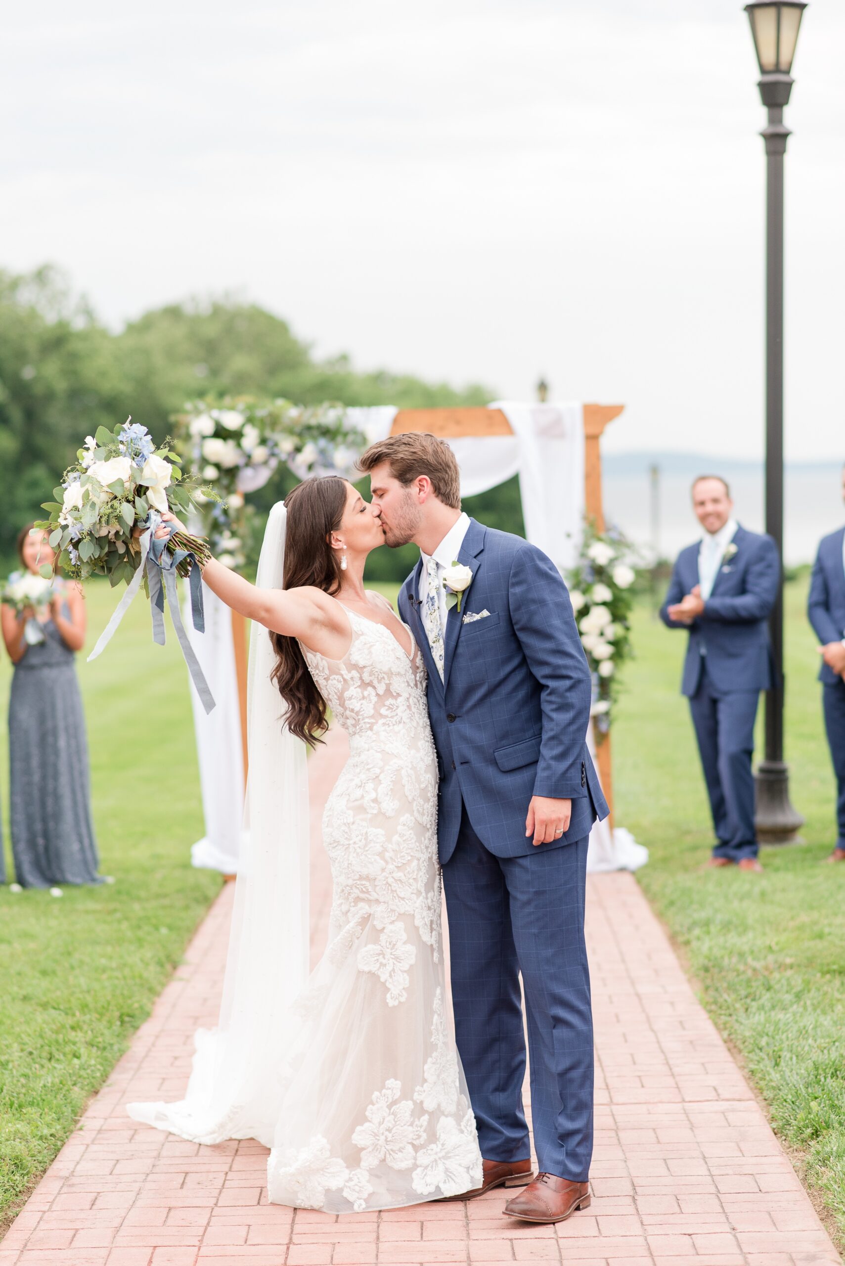 Newlyweds kiss in the aisle while exiting their outdoor Swan Harbor Farm Wedding ceremony
