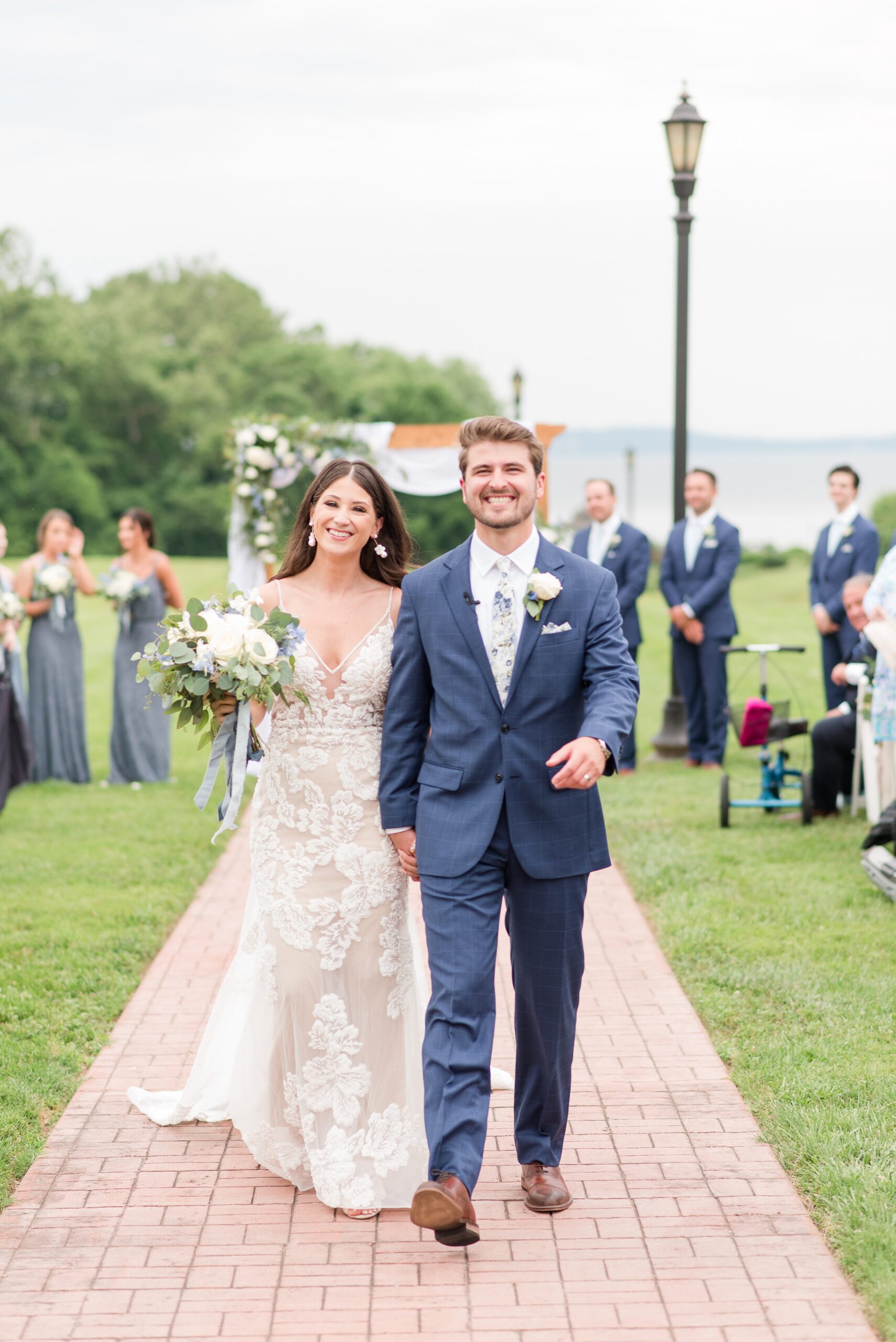 Newlyweds walk back up the aisle holding hands and beaming after their Swan Harbor Farm Wedding ceremony