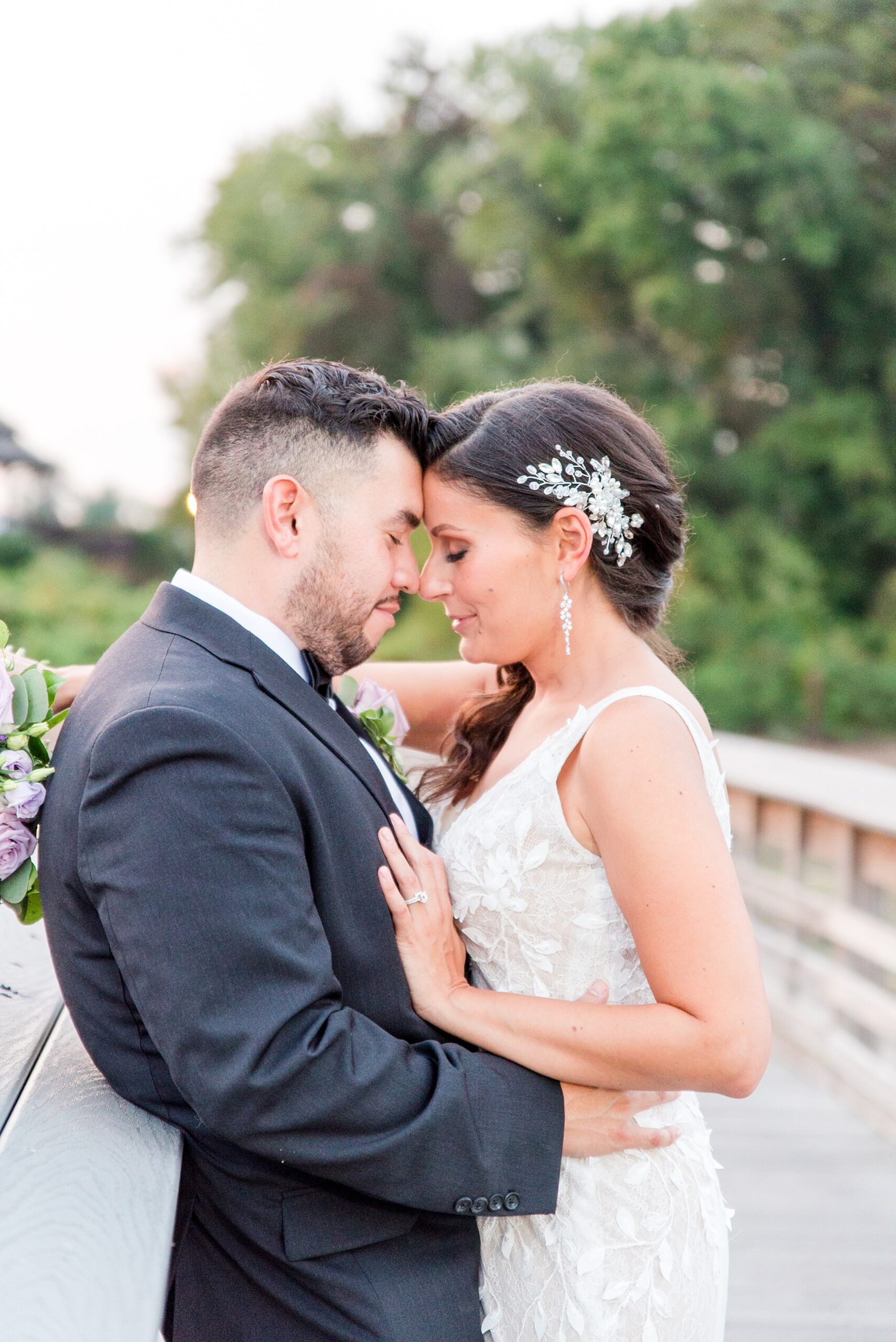 Newlyweds share an intimate moment hugging and leaning on a boardwalk