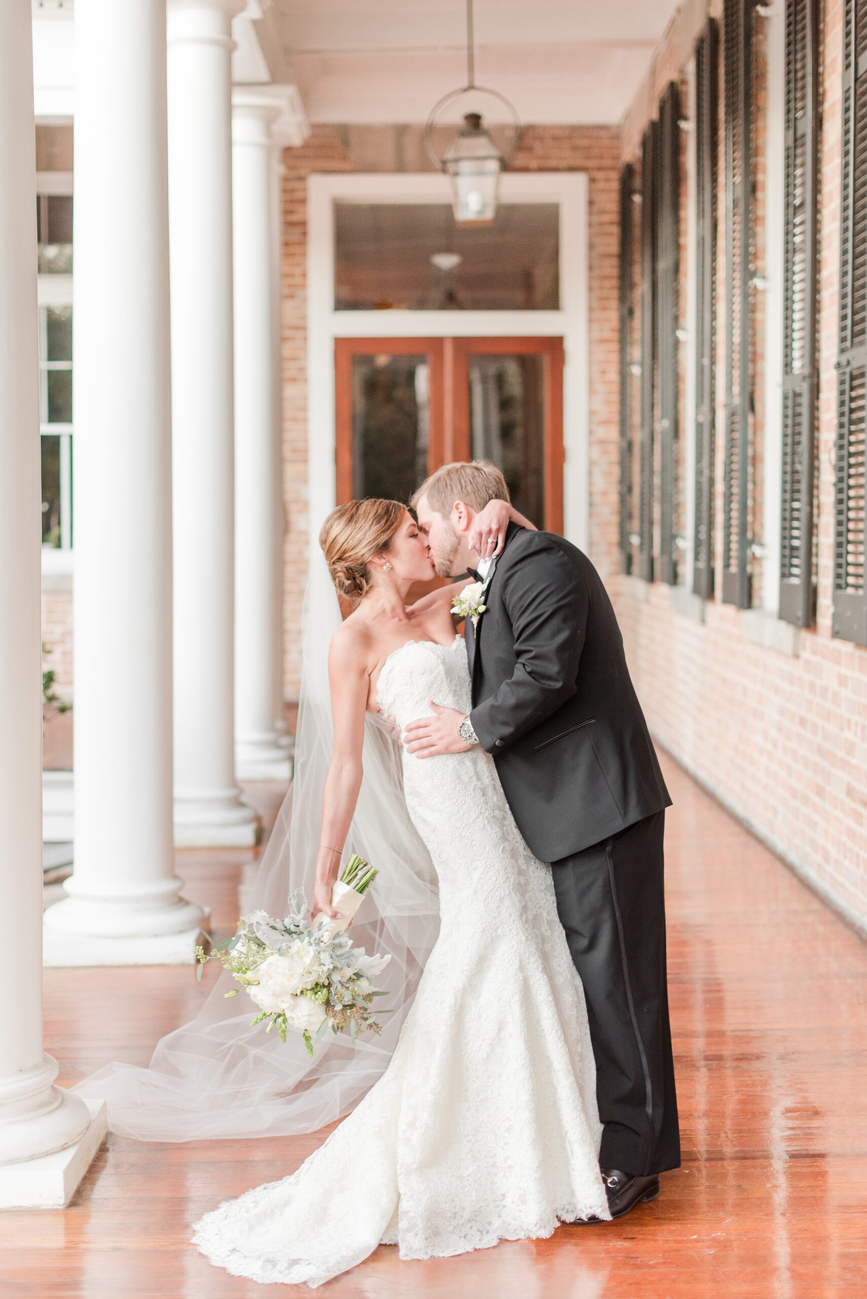 Newlyweds kiss on a porch after using Annapolis Wedding Planners