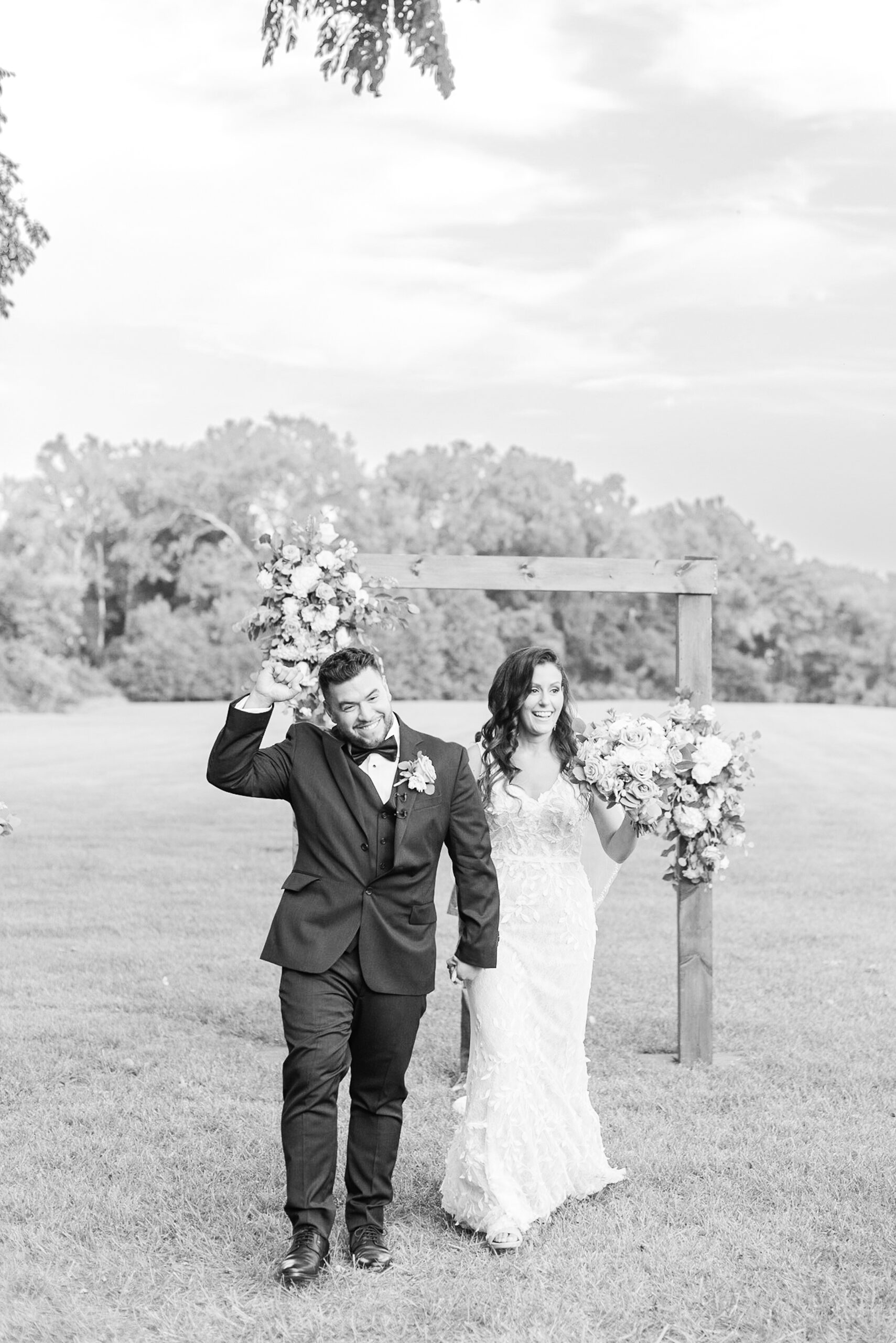 Newlyweds exit their outdoor wedding ceremony with big smiles