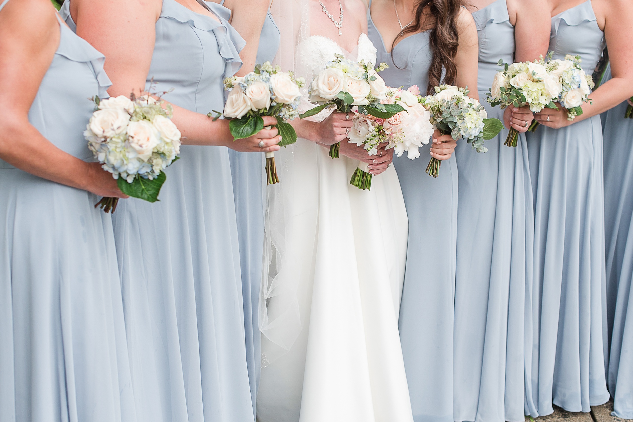 Details of a bride and her bridesmaids holding their bouquets