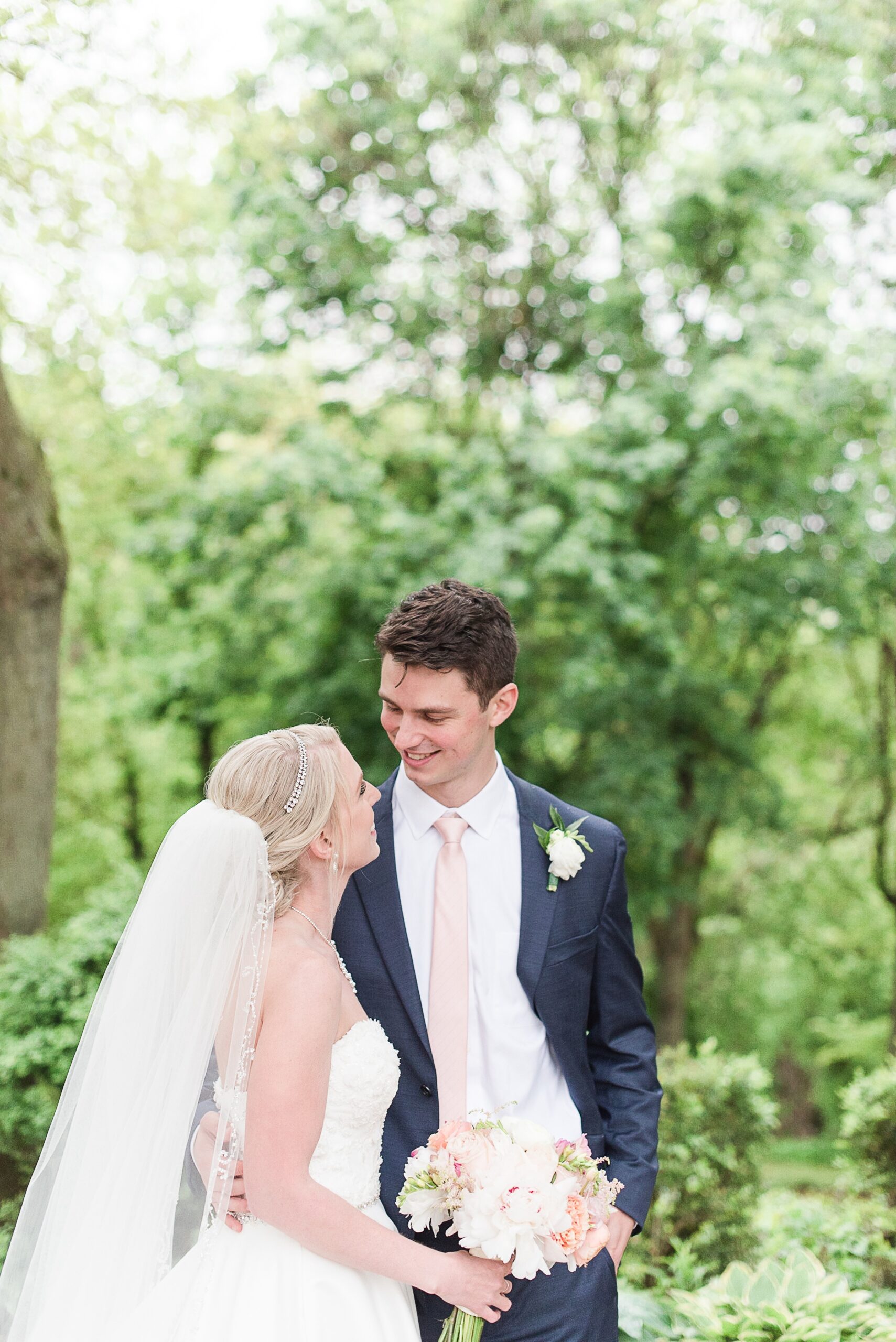 A bride and groom smile at each other in the garden at their Ceresville Mansion Wedding