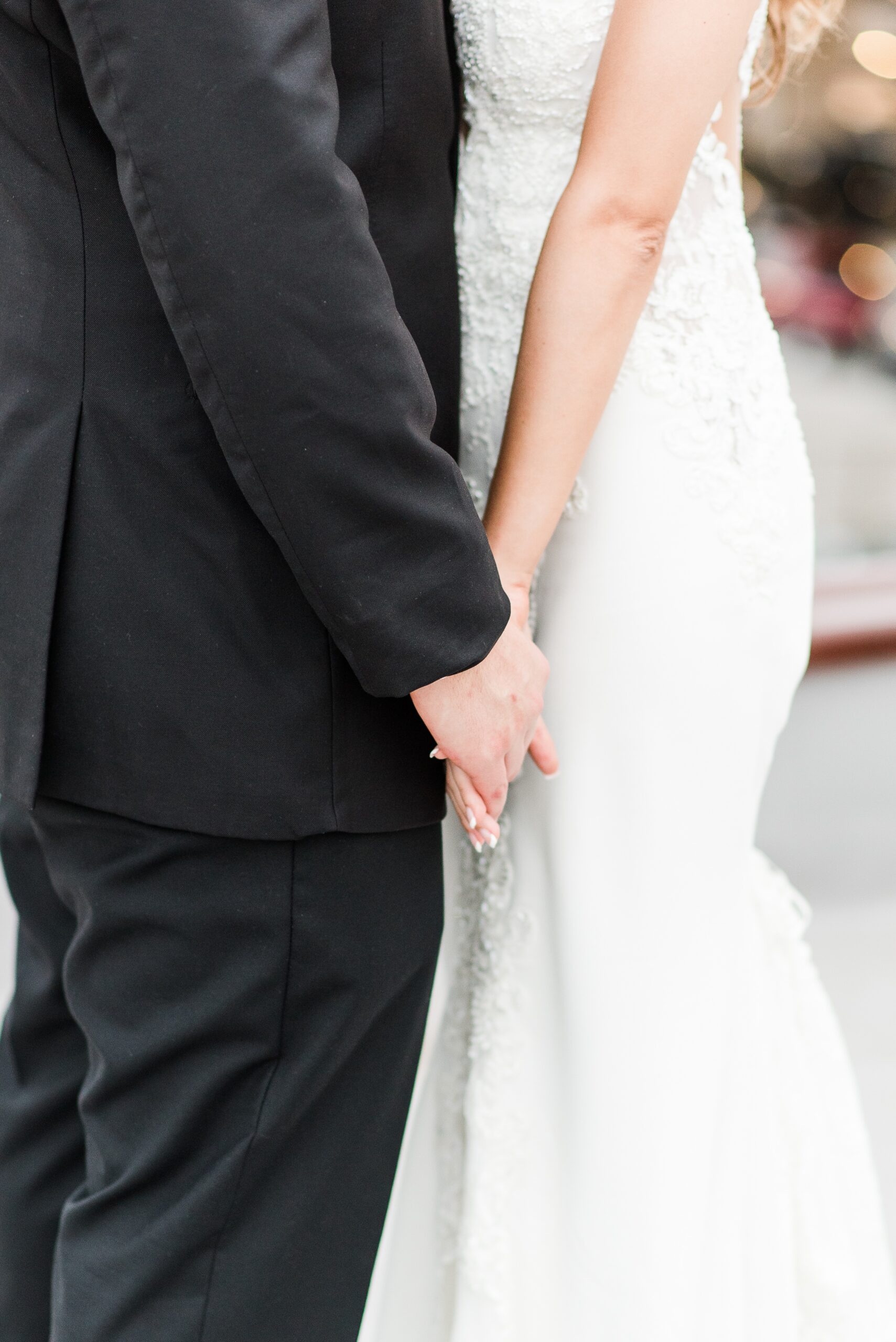 Newlyweds hold hands gently while standing close at their Cloisters Castle Wedding