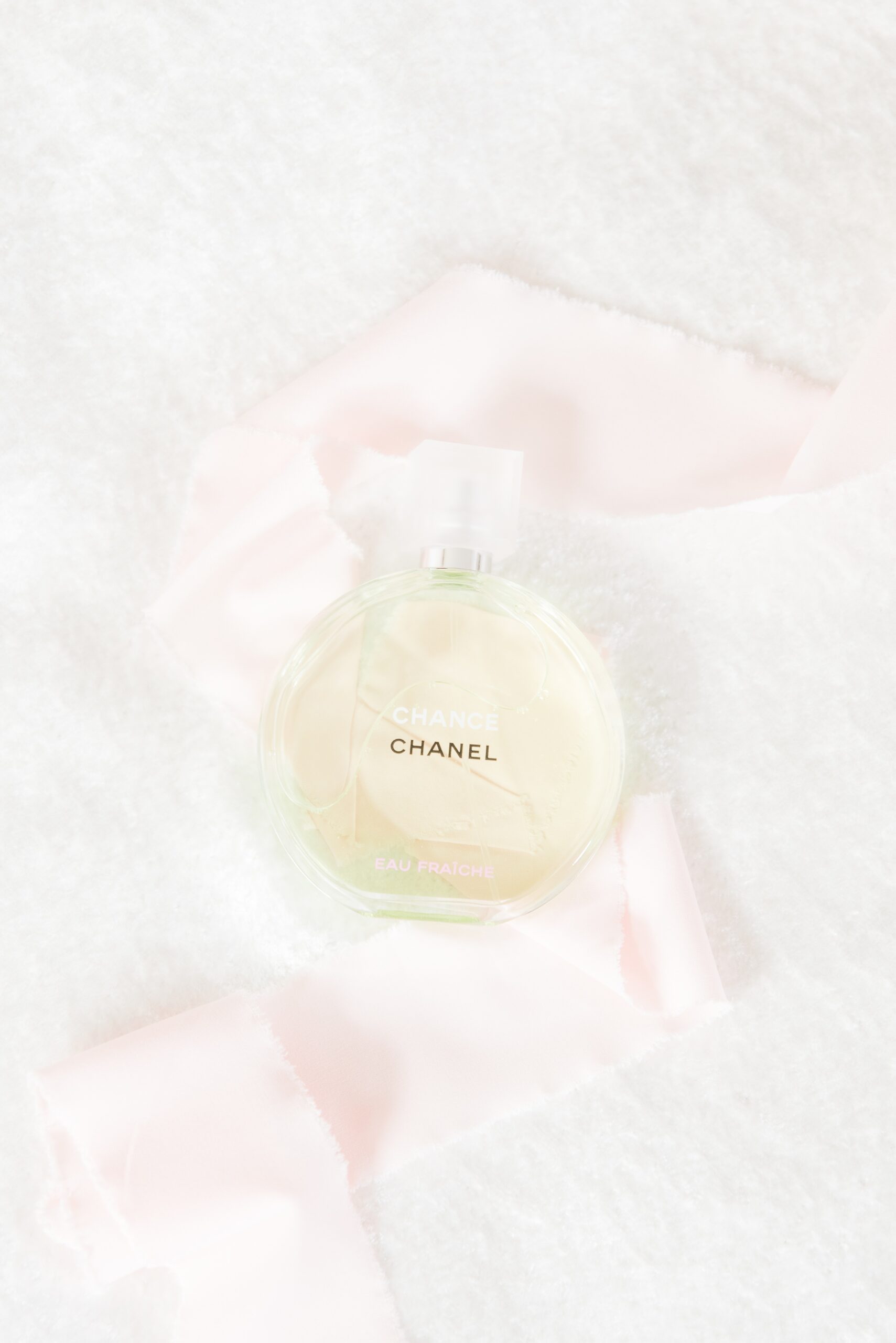 Details of perfume with a pink ribbon