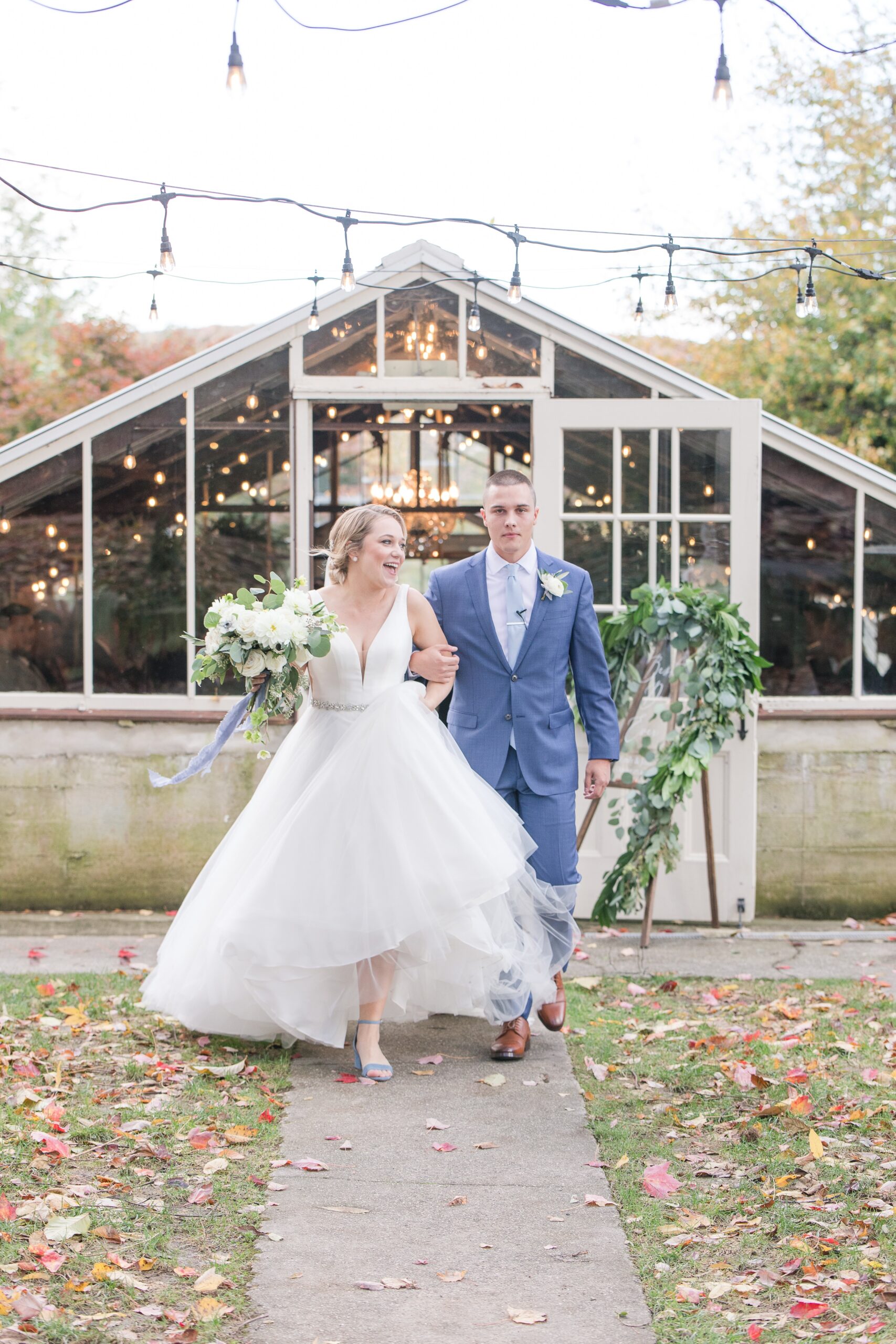 Newlyweds exit their greenhouse Historic Shady Lane Wedding ceremony under market lights