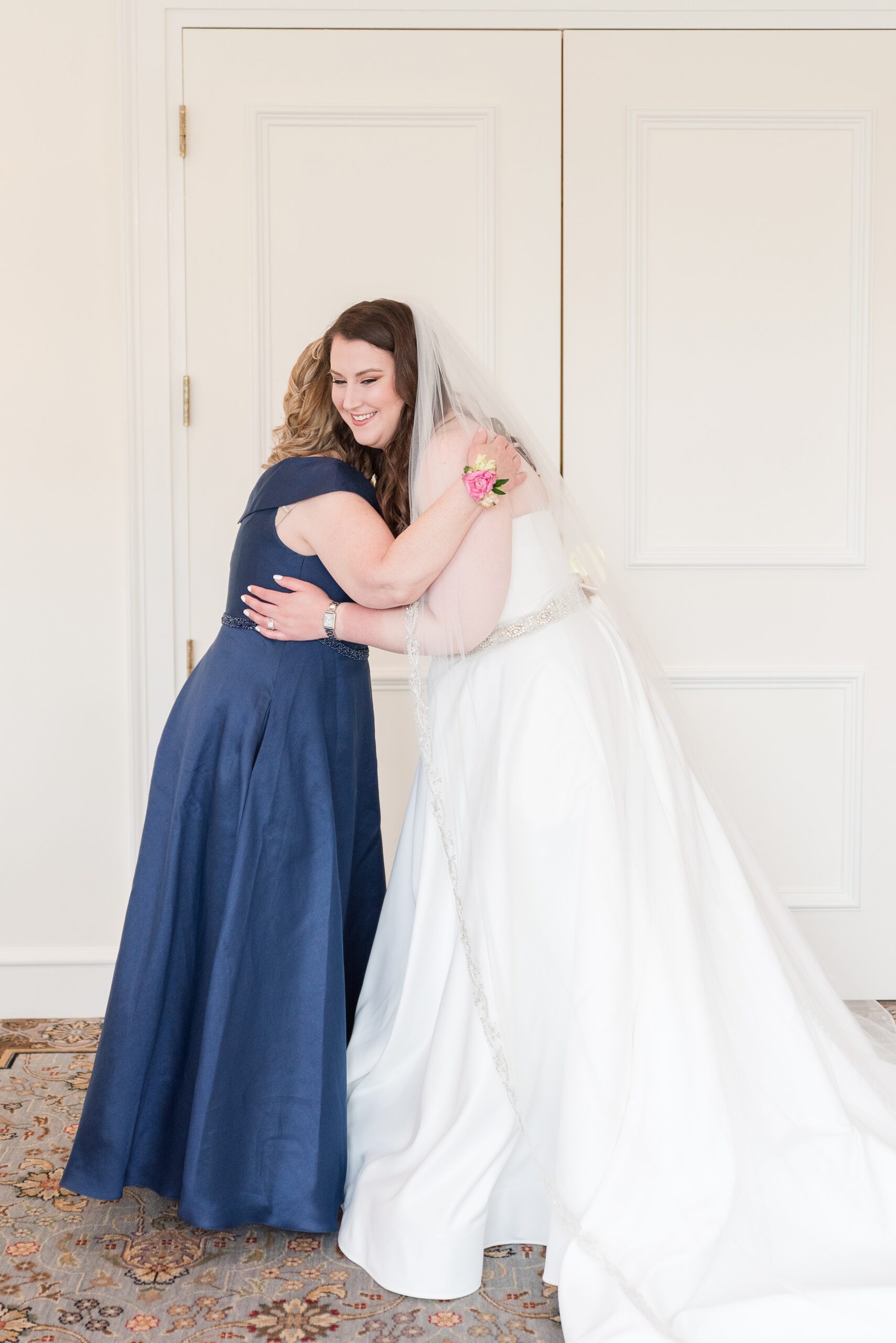 A bride hugs her mom while getting ready for her wedding