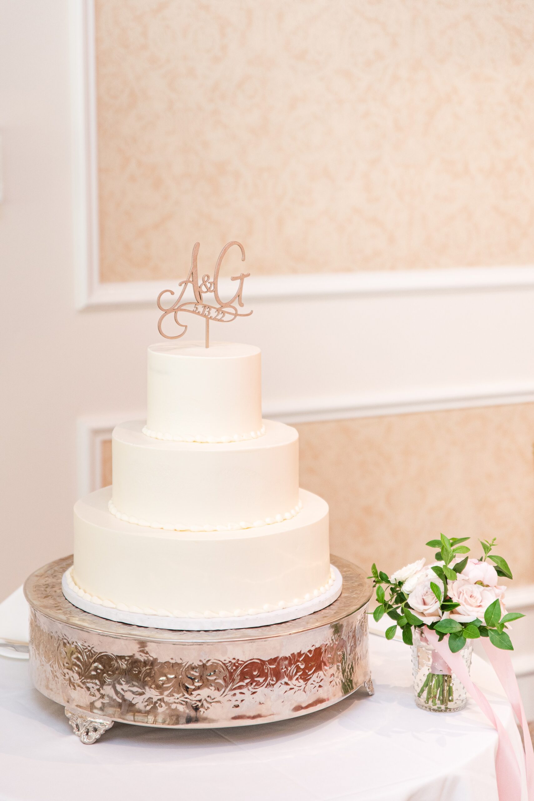 Details of a three tier white wedding cake on a silver stand