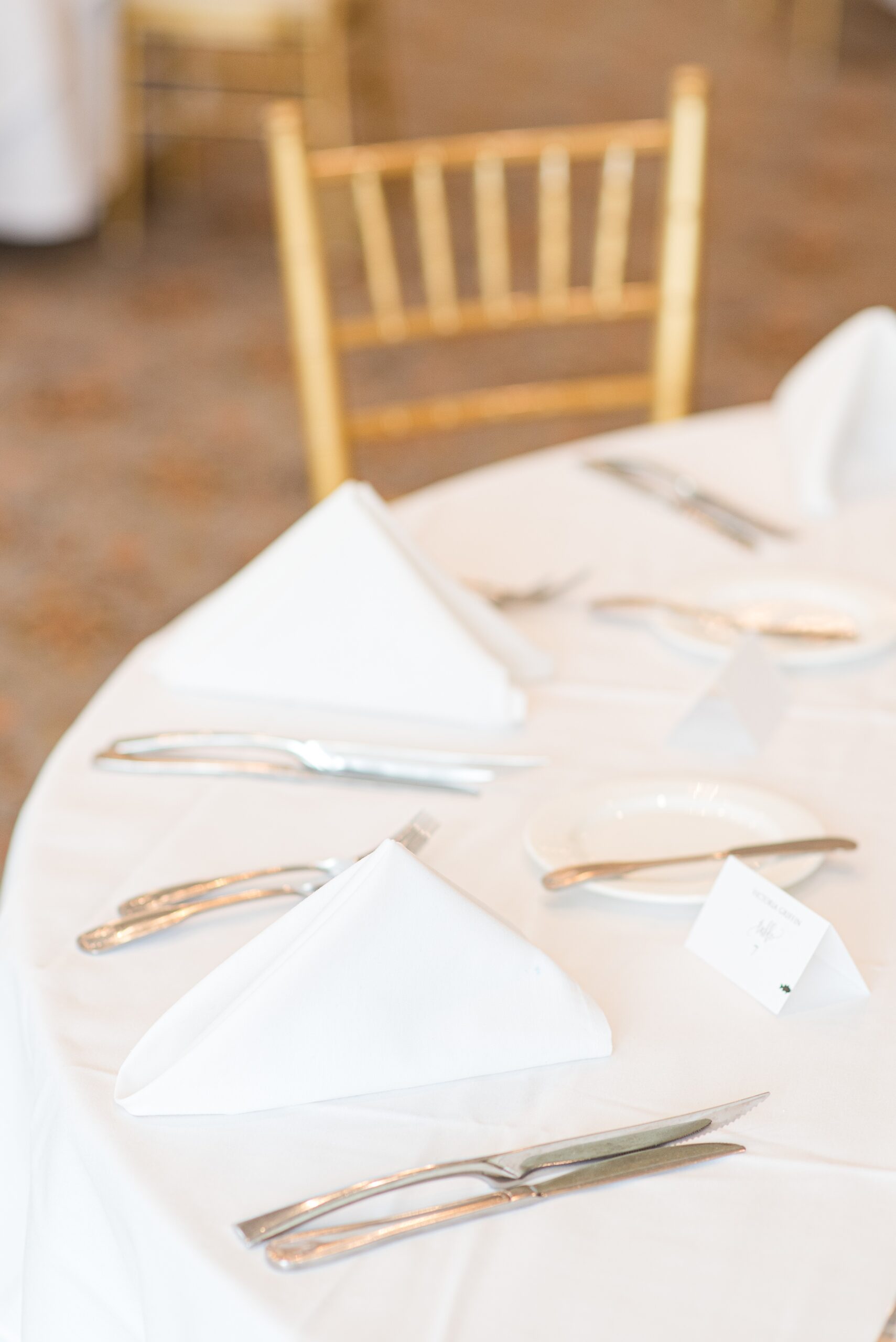 Details of a Manor Country Club Wedding reception table set up with white napkins and silverware