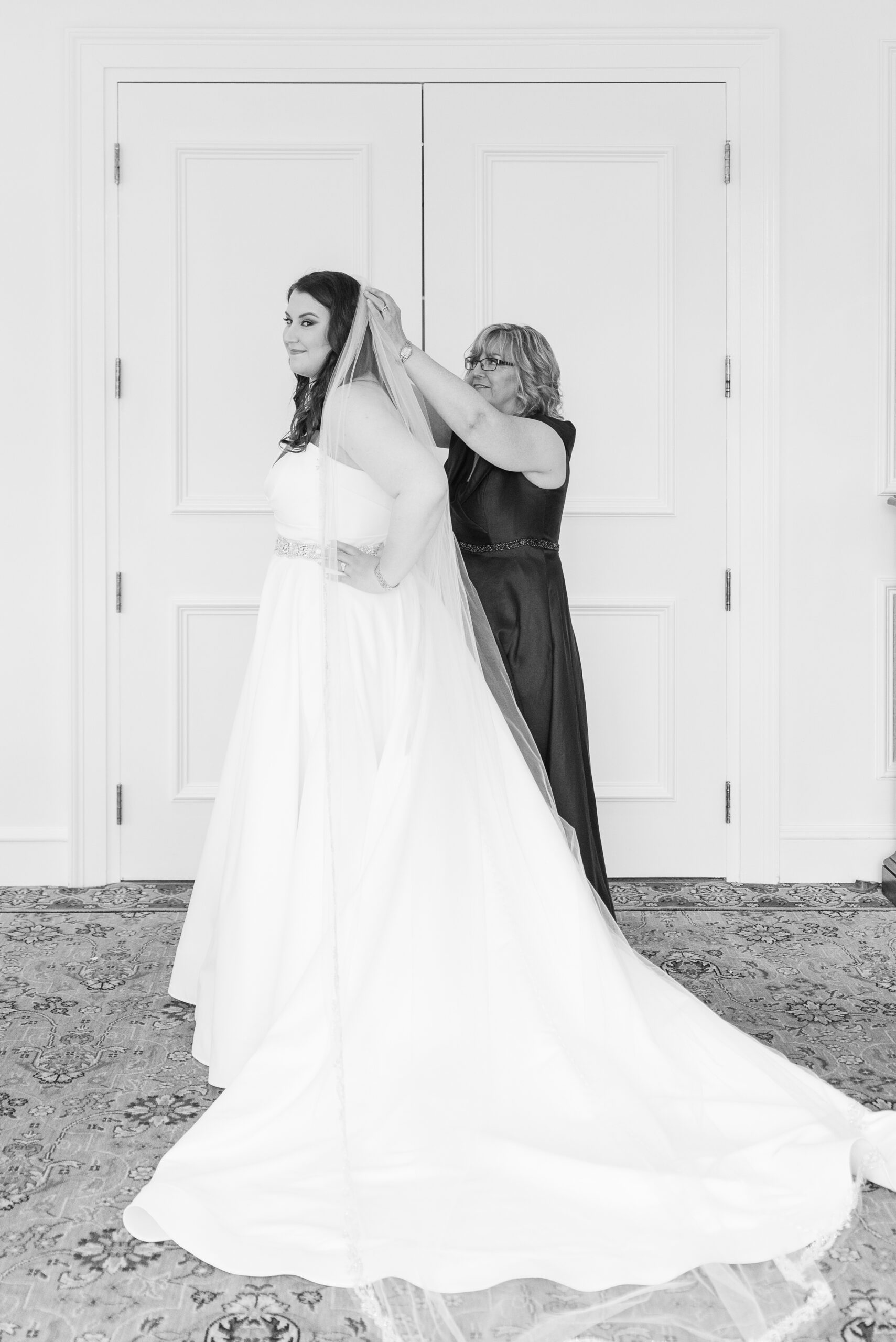 A bride gets help from mom putting on her veil