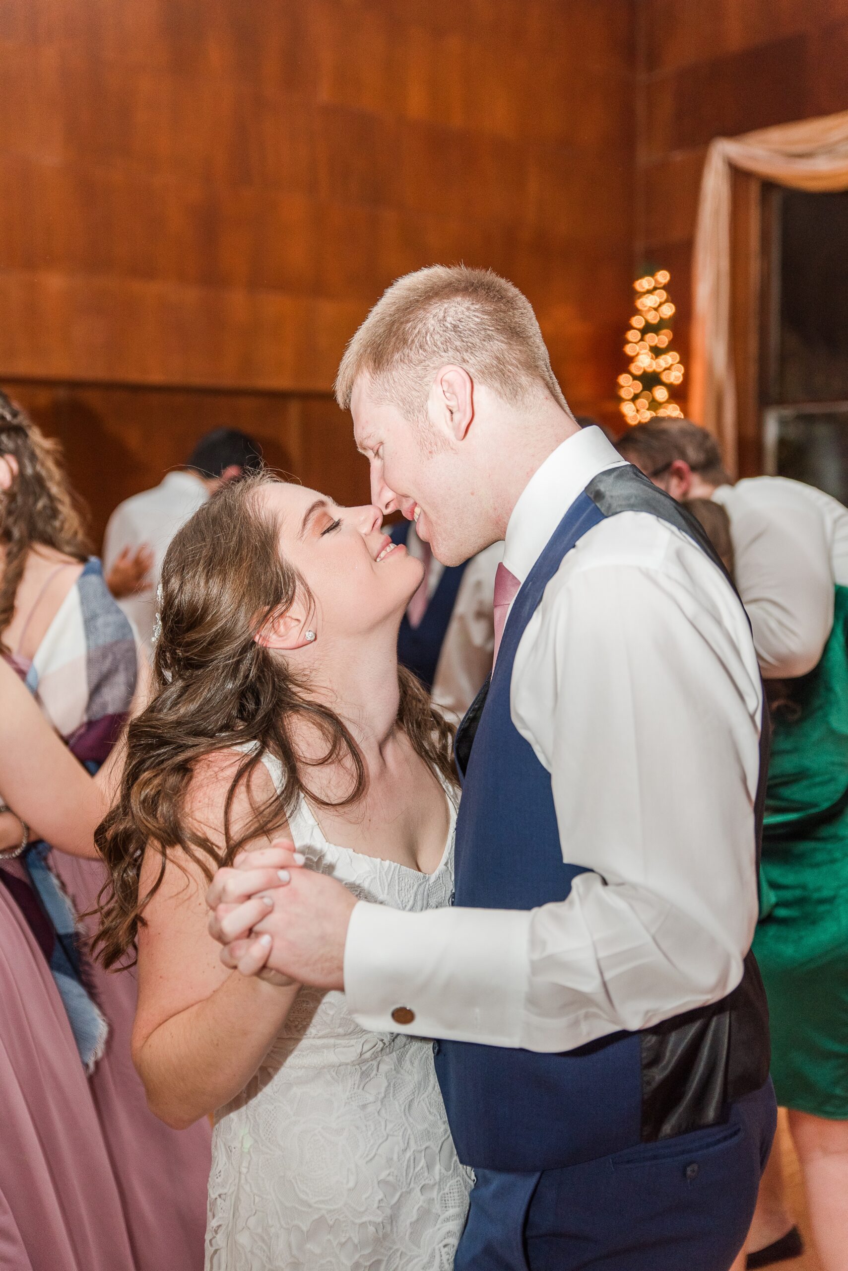 Newlyweds dance with their guests and lean in for a kiss