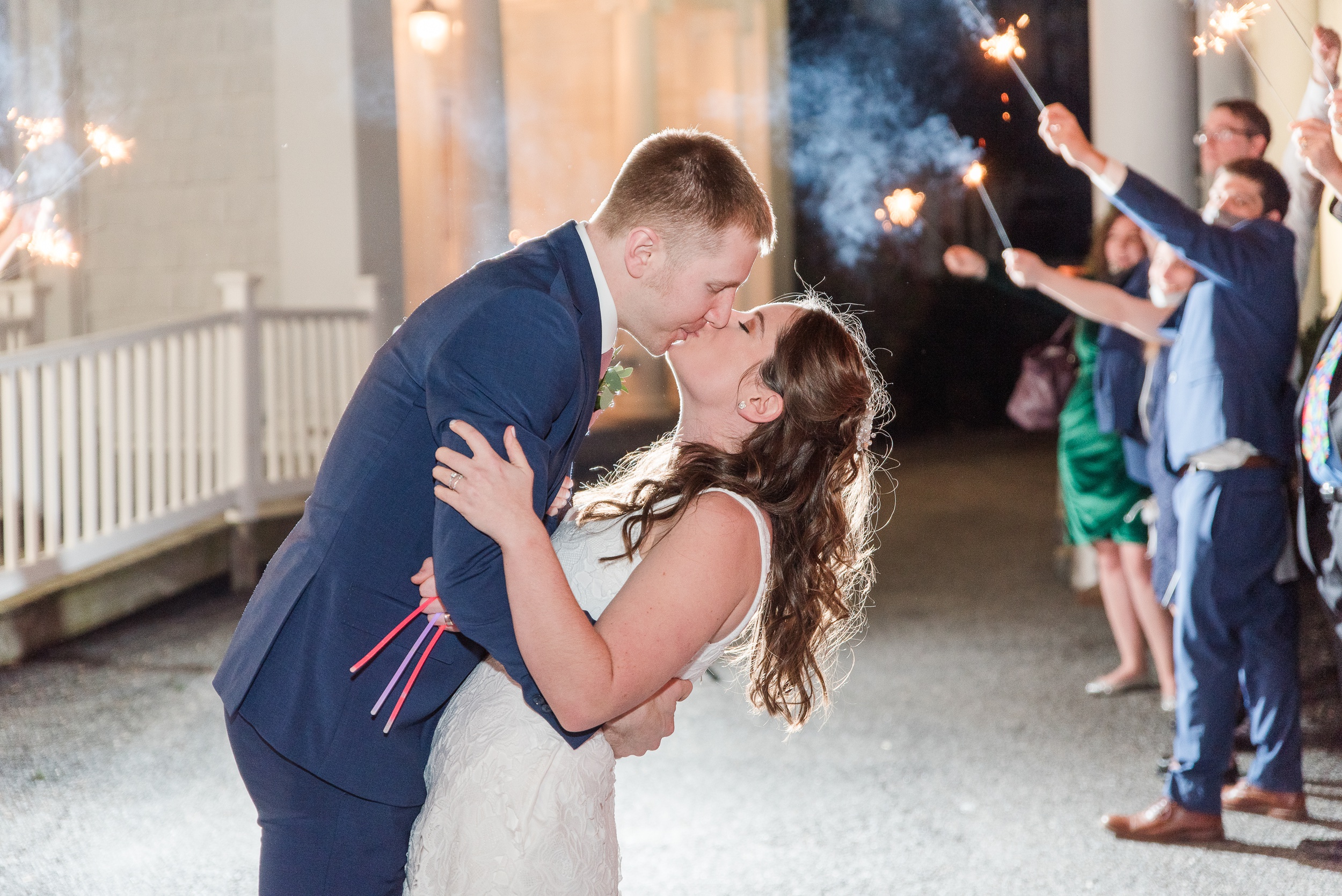 Newlyweds kiss while under an arch of sparklers to end their Overhills Mansion Wedding