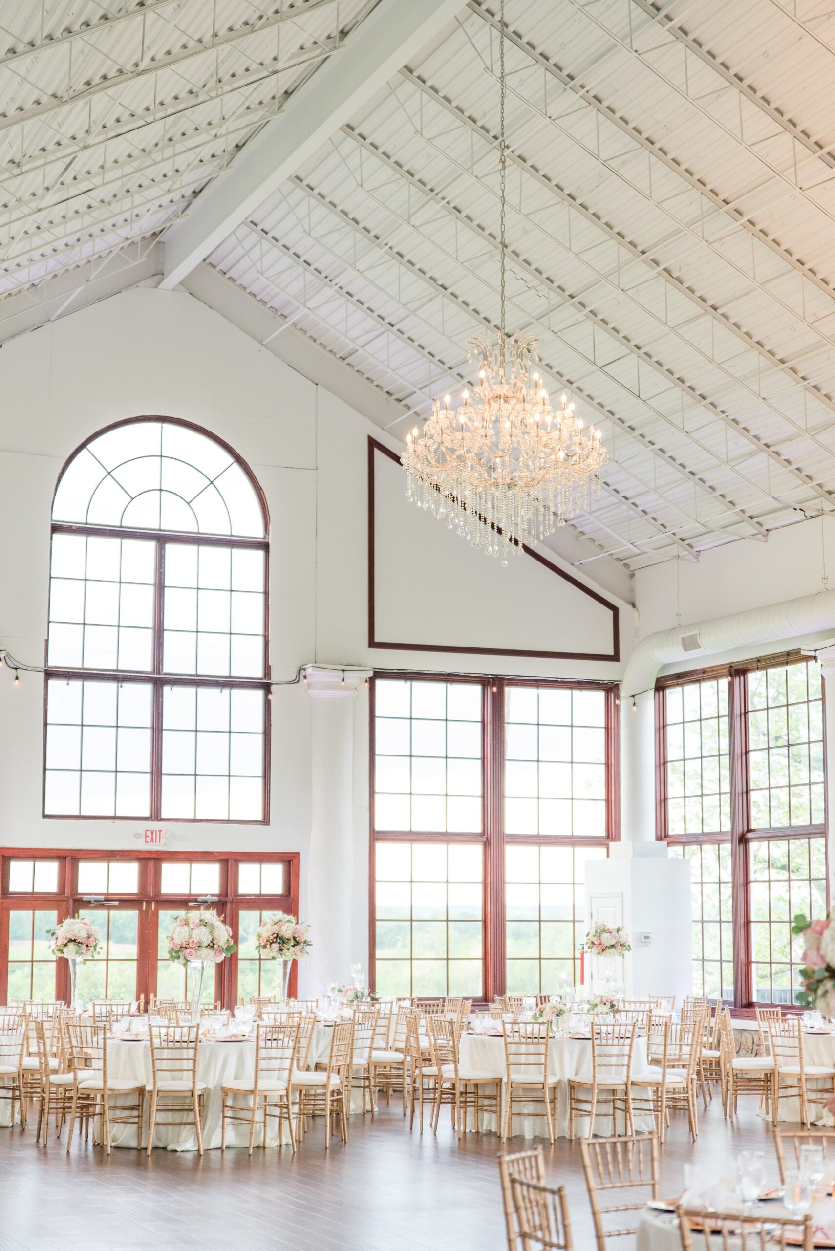 A view into a Raspberry Plain Manor Wedding reception set up with the large chandelier turned on