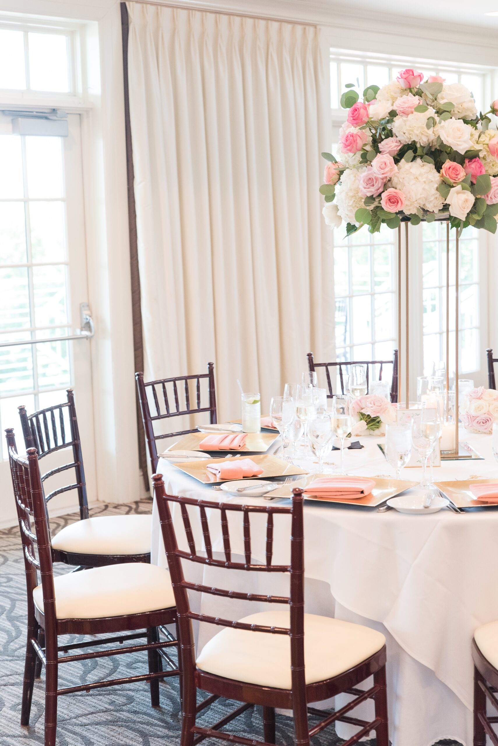 Details of a wedding reception table with tall florals and candles