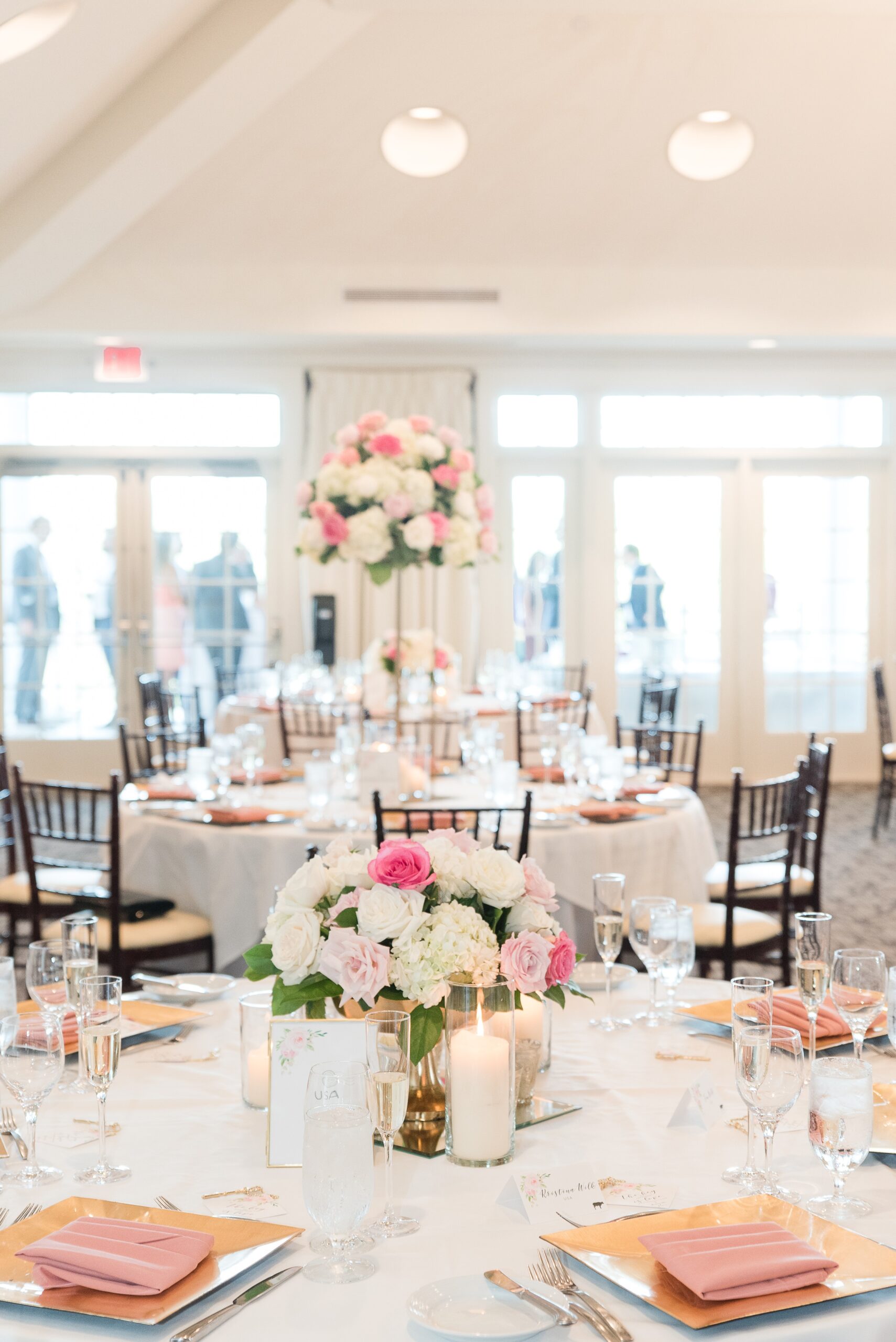 Details of a wedding reception table with pink and white roses and pink napkins at a River Creek Club Wedding