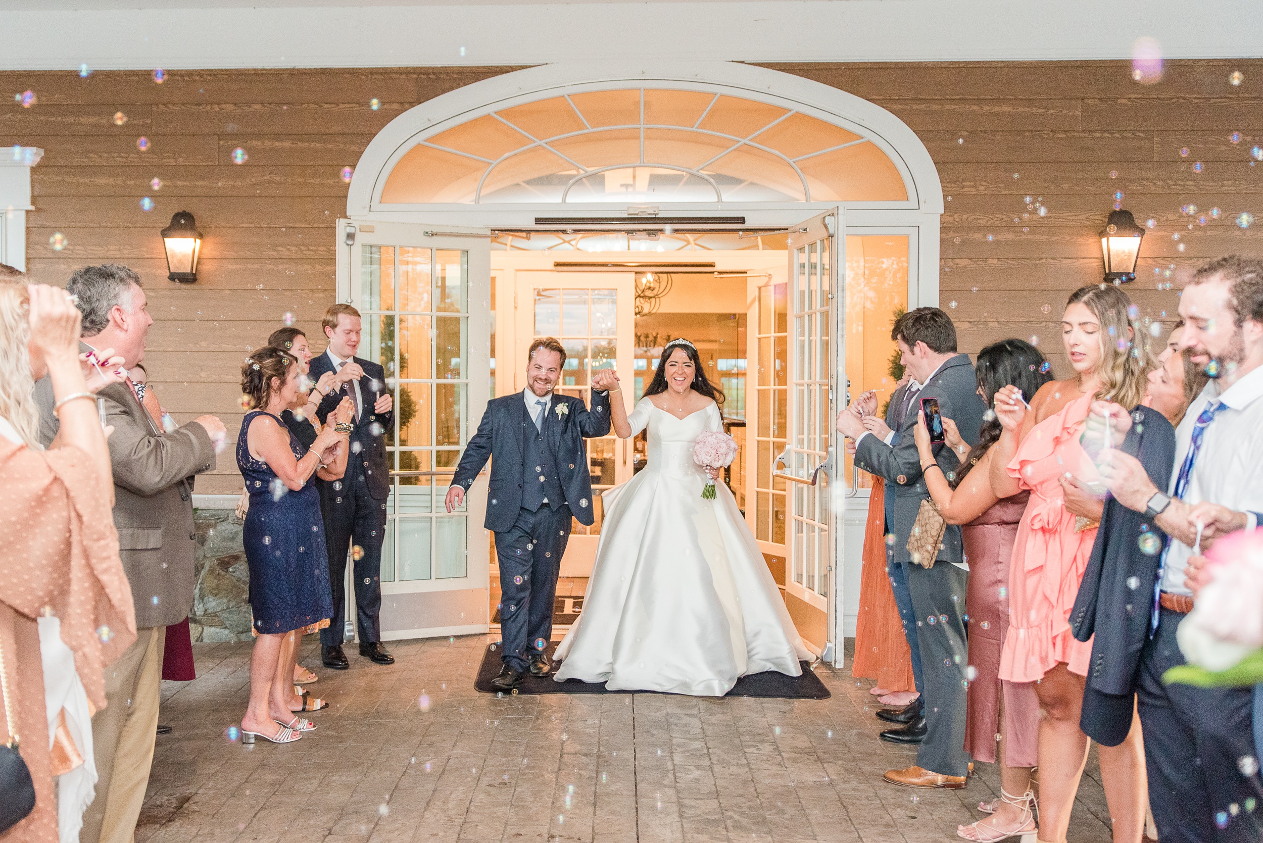 Newlyweds walk under a sea of bubbles to exit their wedding reception