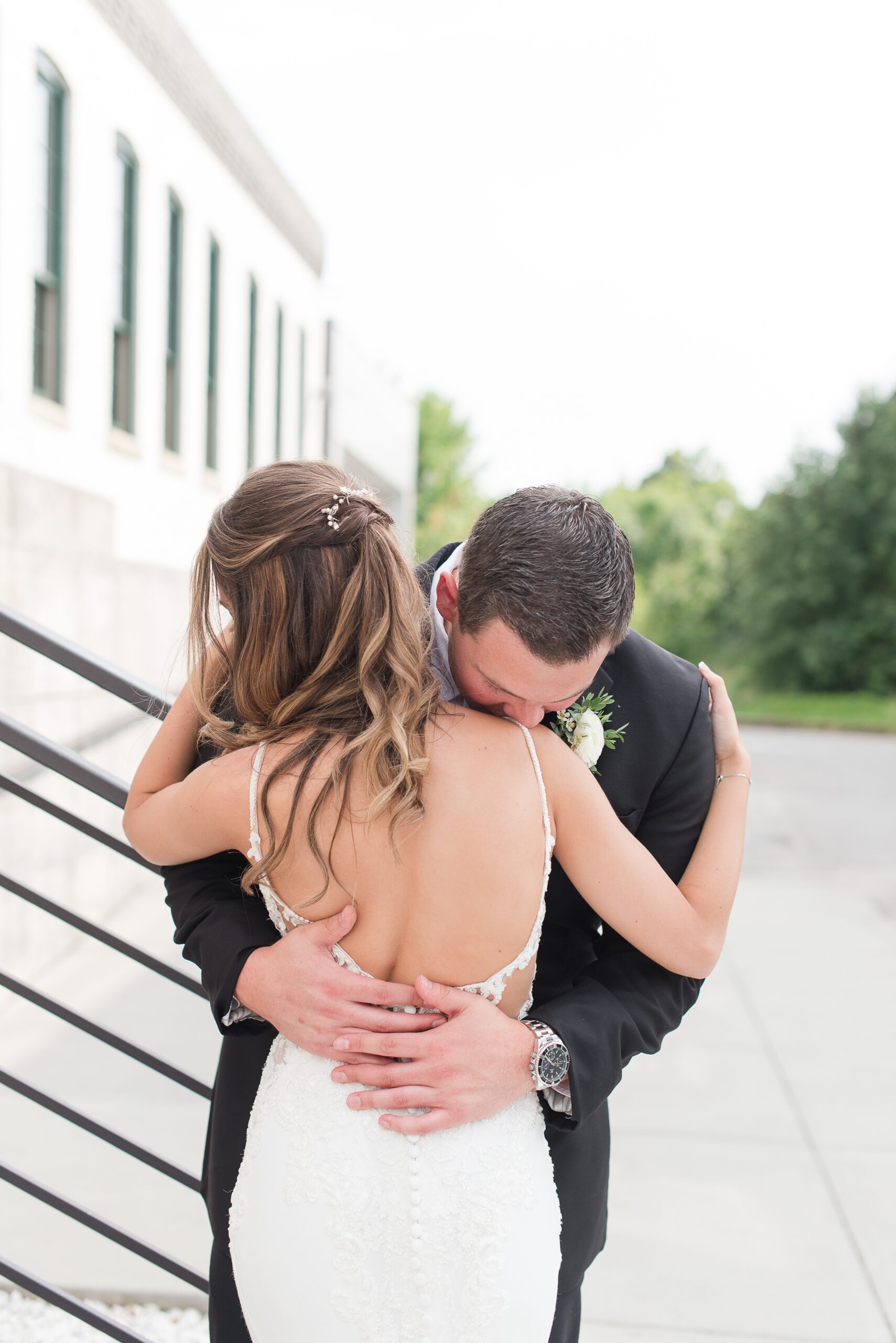 Newlyweds share a hug in an intimate moment behind The Winslow Baltimore