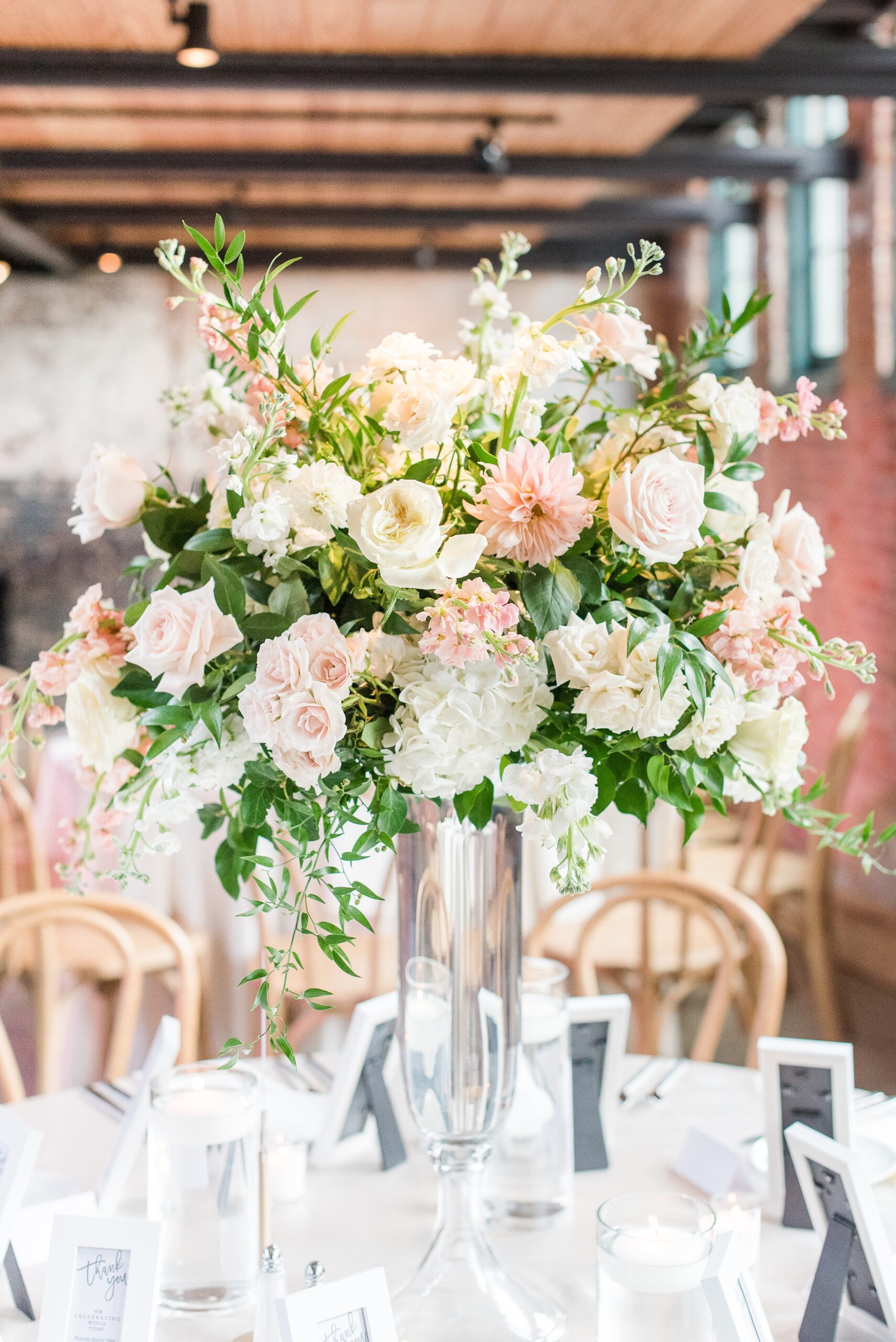 Details of a tall white and pink rose bouquet on a wedding reception table