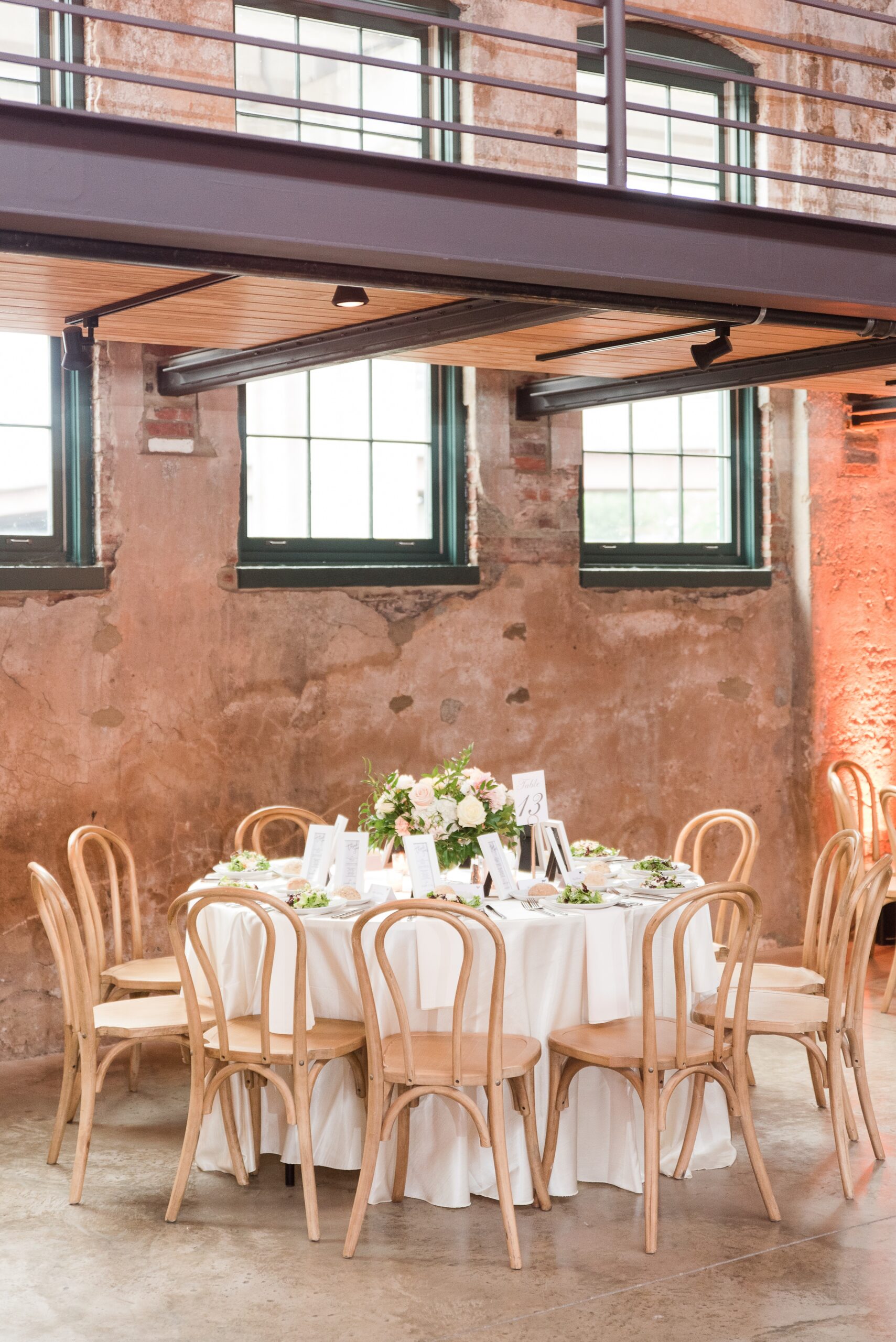 Details of a wedding reception table with floral center piece and salads at The Winslow Baltimore