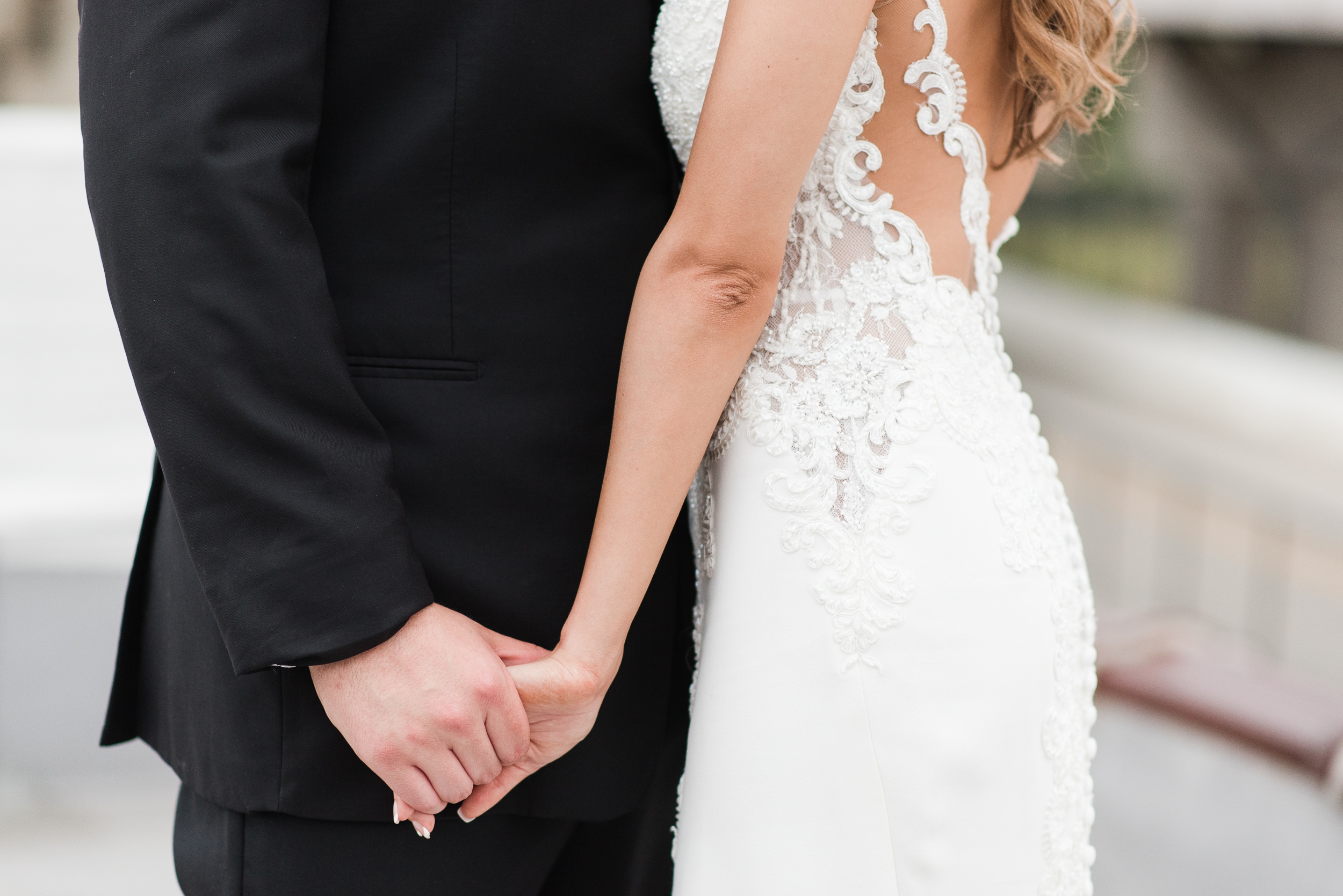 Newlyweds hold hands while standing close