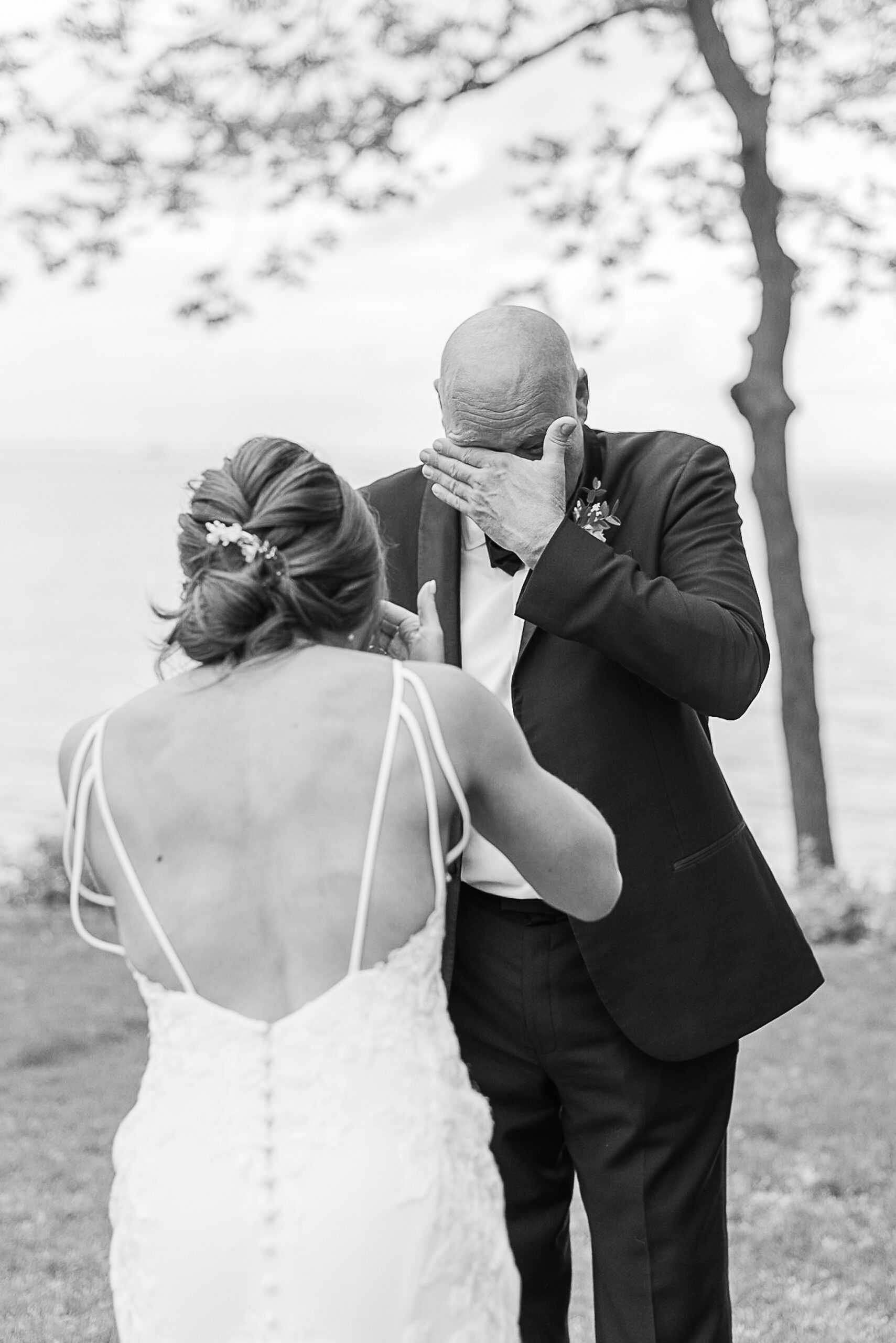 A bride and groom wipe away tears during their first look at their Tidewater Inn Wedding