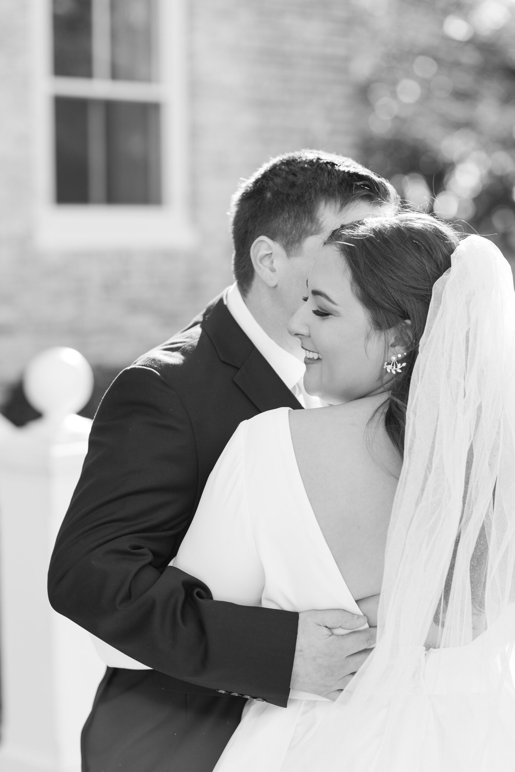 Newlyweds dance in a garden in black and white