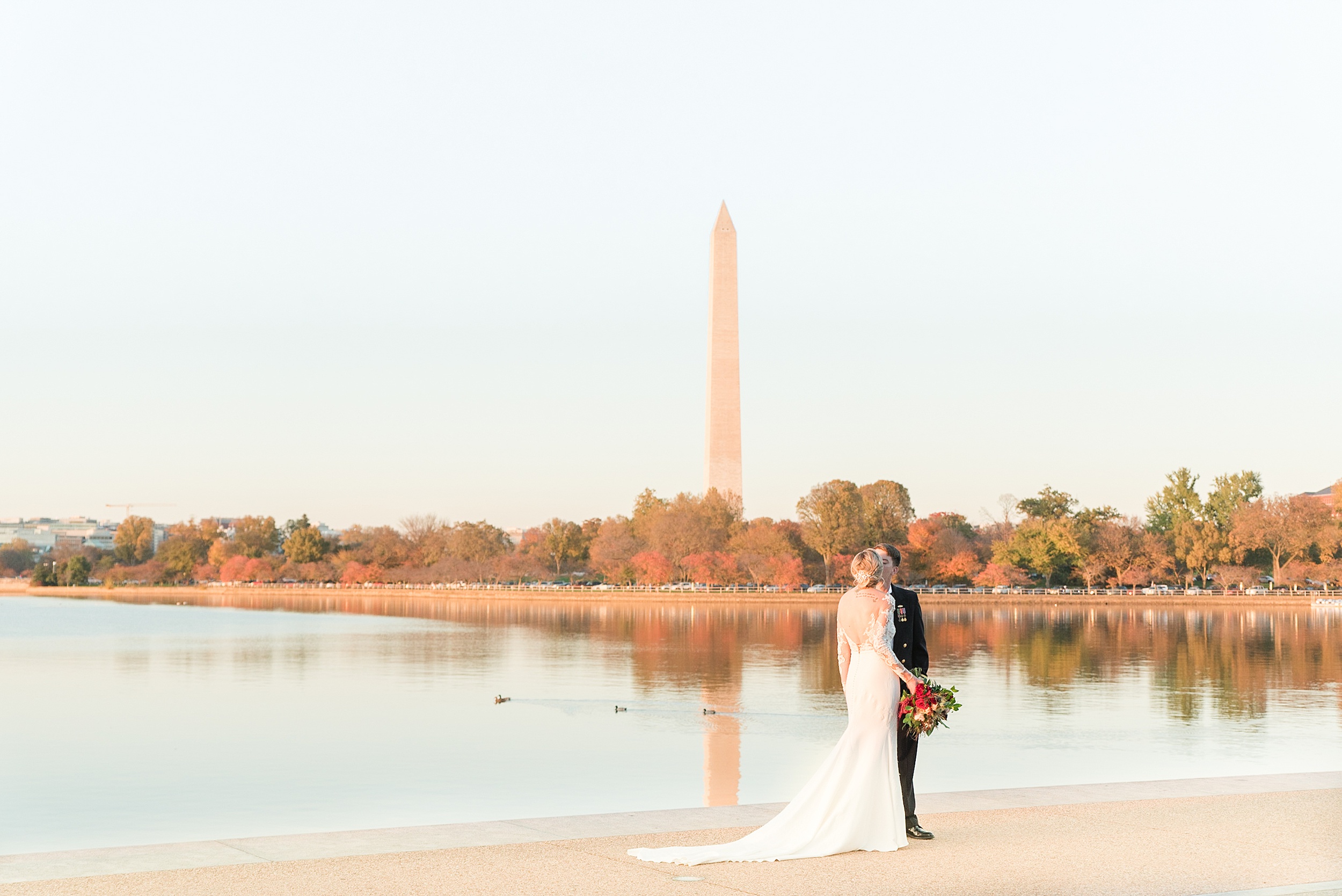 Newlyweds kiss on the water in the park during their wedding