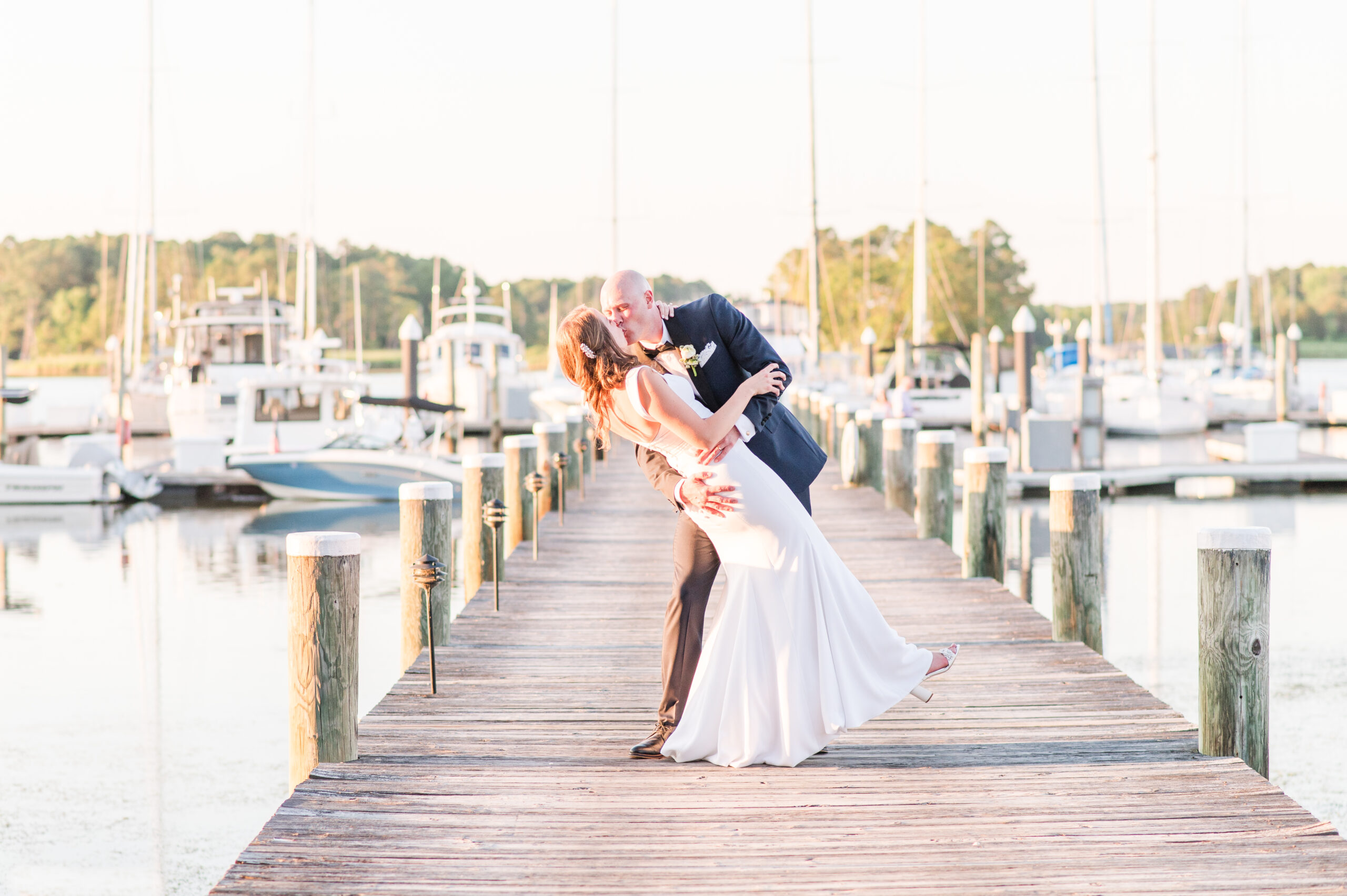 bride and groom at sunset on the marina dock dipping