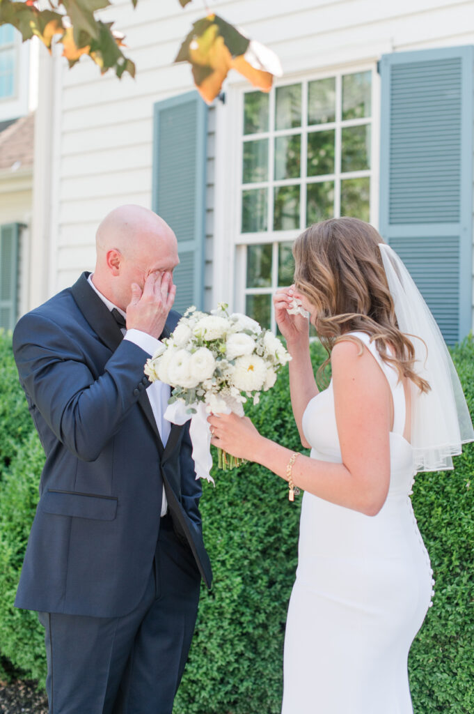 couple crying during first look in front of wedding venue