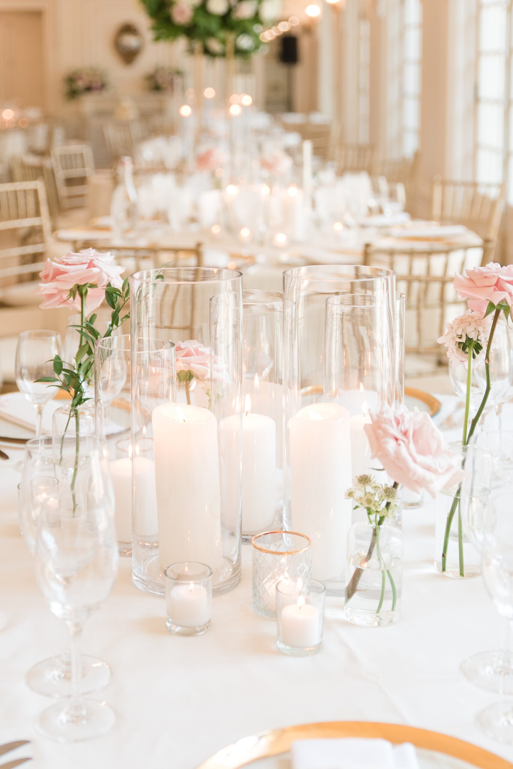 Details of a wedding reception table set up with pink roses and candles