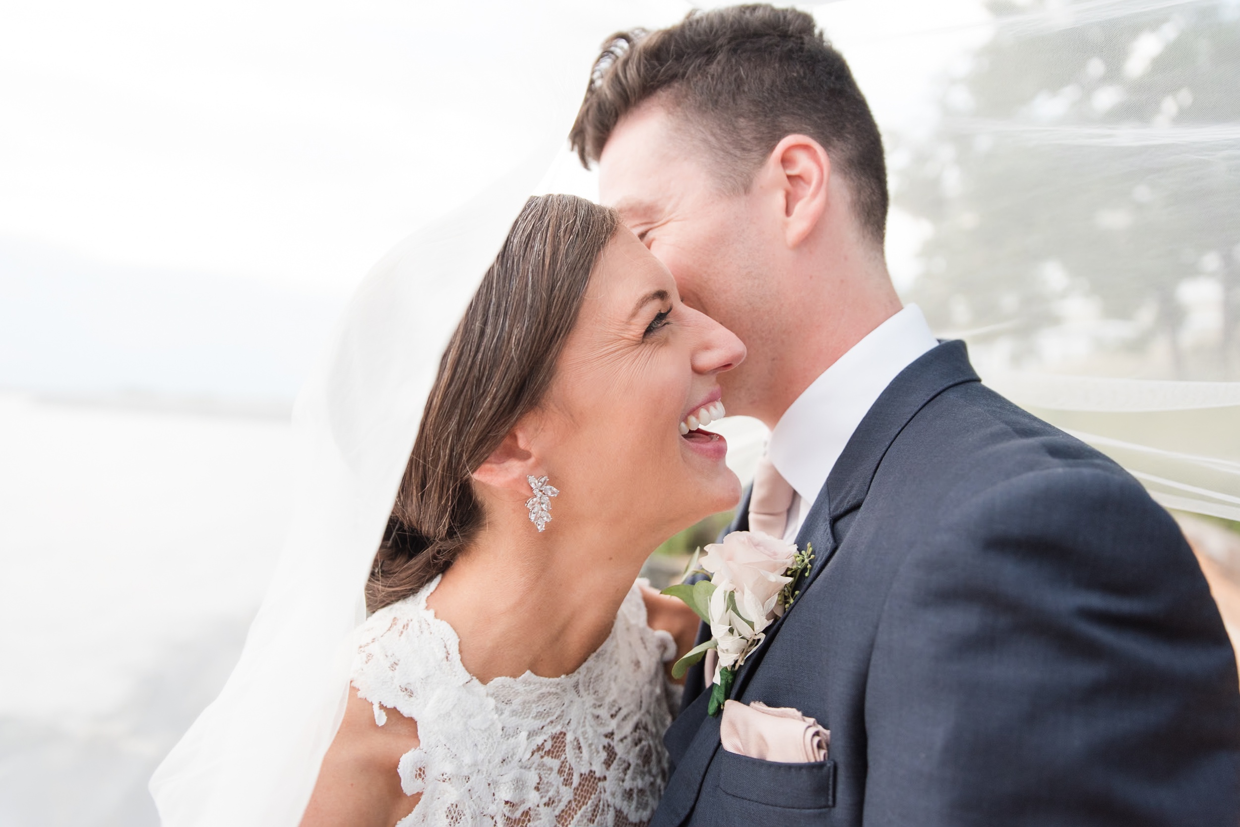 Newlyweds laugh and hide under the veil at their Whitehall Wedding