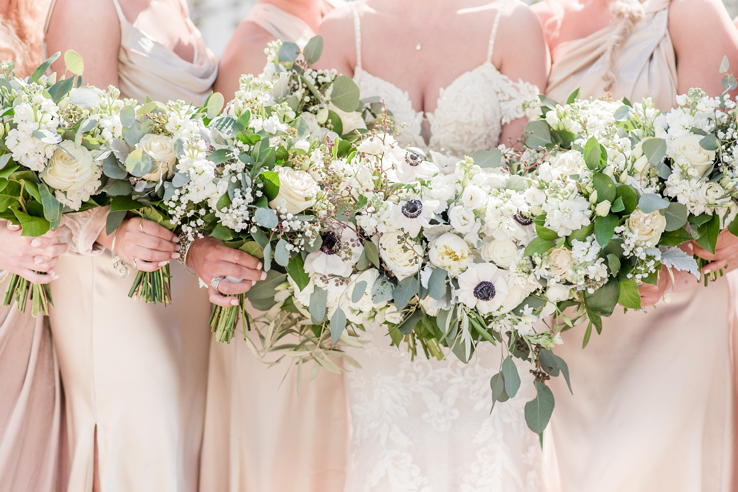 Details of a bride's white assorted bouquet with her bridesmaids at her Whitehall Wedding